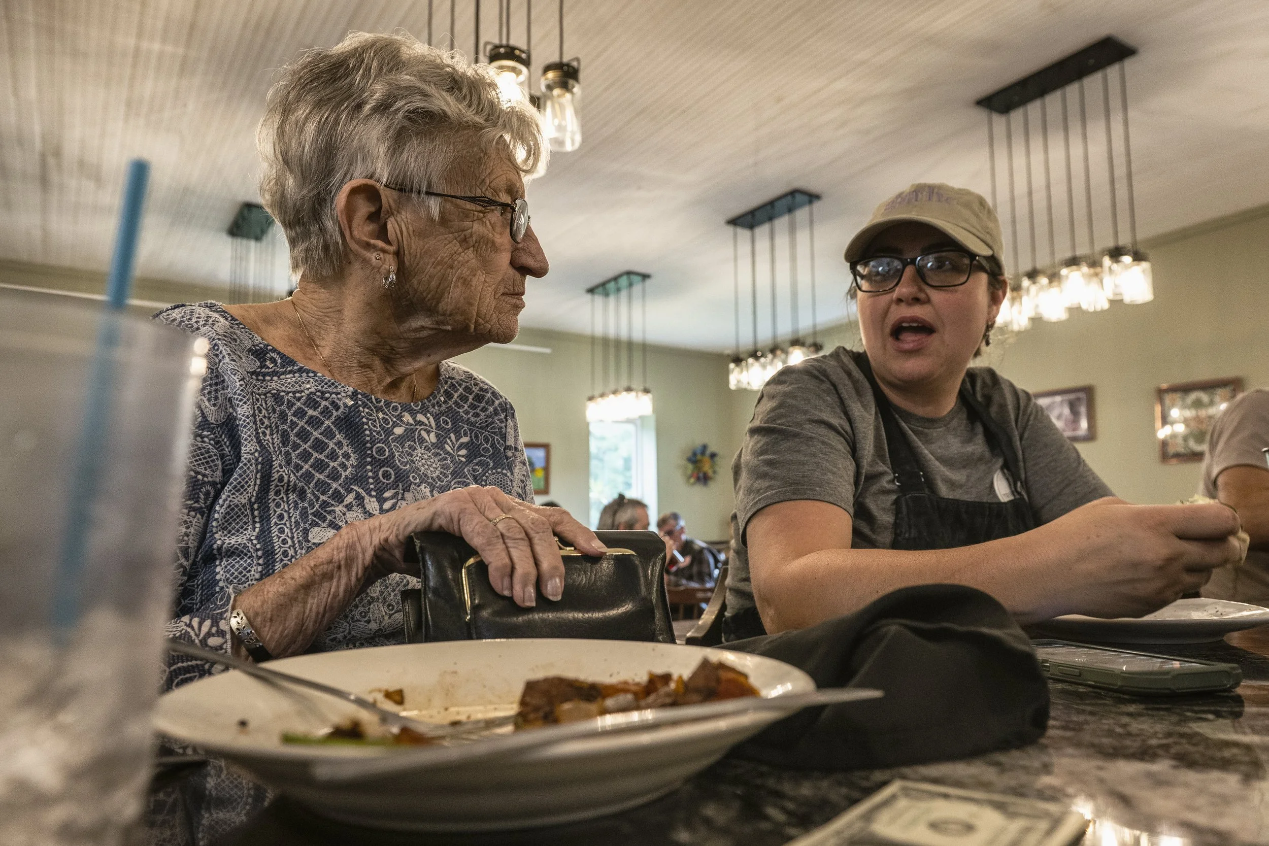  Rosie Berardi, co-owner and co-founder of the Triple Nickel Diner, chats with her aunt, Barbara Fischer, one of the elders of the village, during a meal break at the diner in Chesterhill, Ohio, on Thursday, Aug. 28, 2025. Berardi usually eats only a
