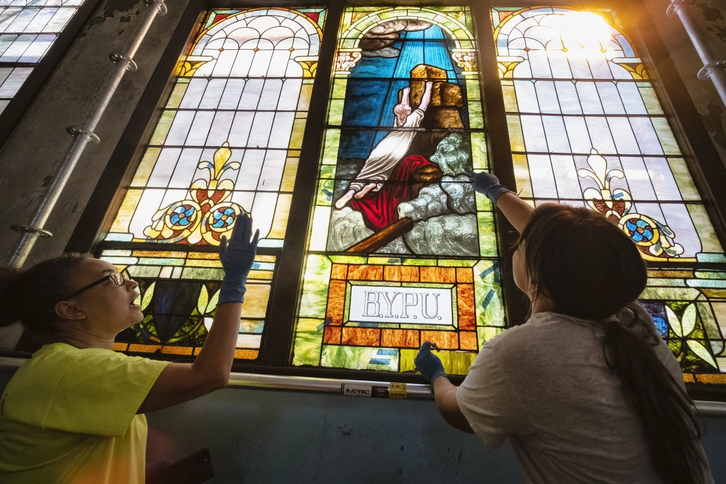  Nzilani Glass Conservation's Founder Ariana Makau, 51, left, of Oakland, Calif., discusses with Blind Eye Restoration's owner Lindsay Jones, 37, of Columbus, Ohio, the numerous cracks they have spotted on closer inspection while cleaning dust and de