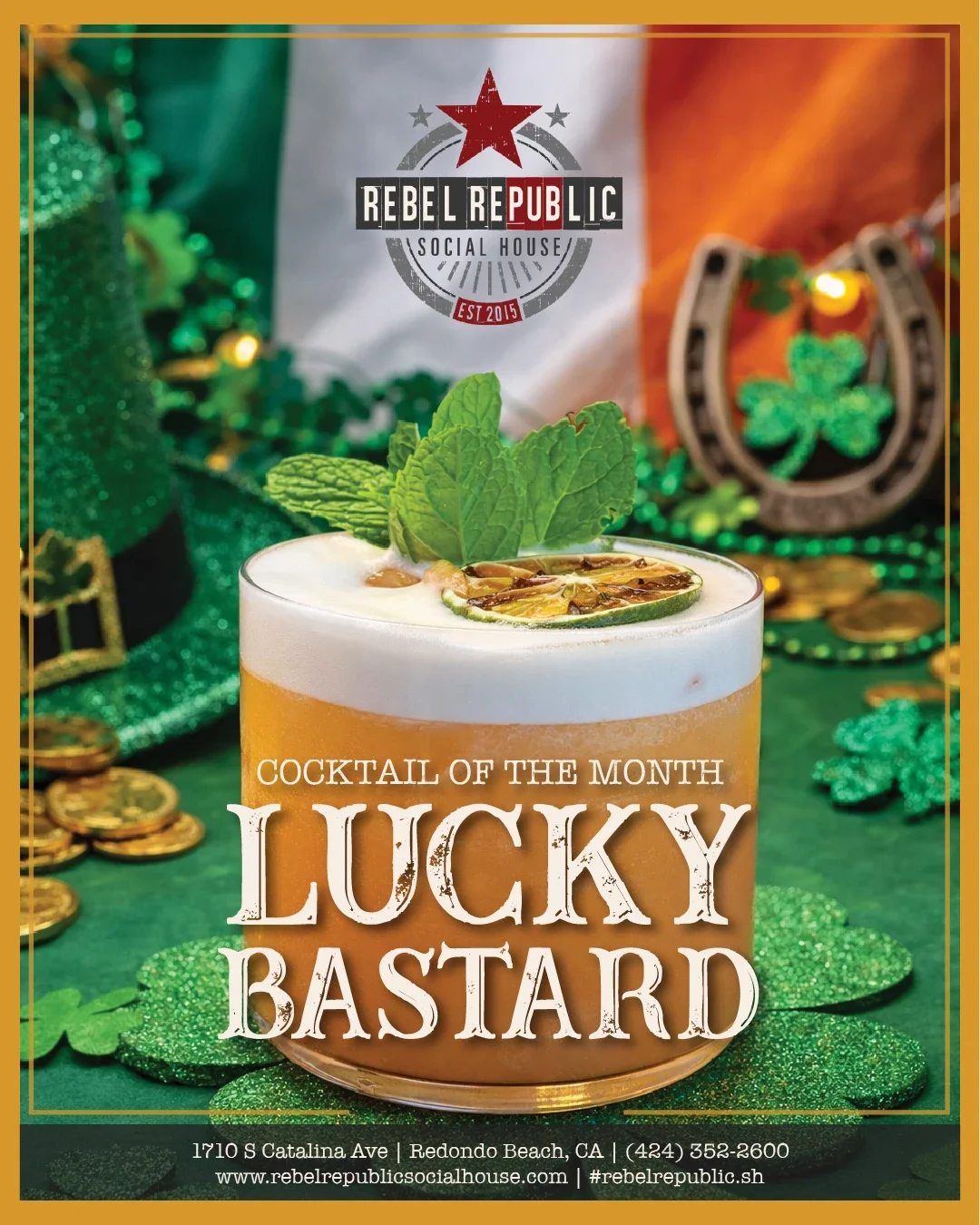 Rebel Republic Cocktail of the Month “Lucky Bastard” – frothy mint & cucumber cocktail on a festive St. Patrick’s Day table with shamrocks, gold coins, & an Irish flag.