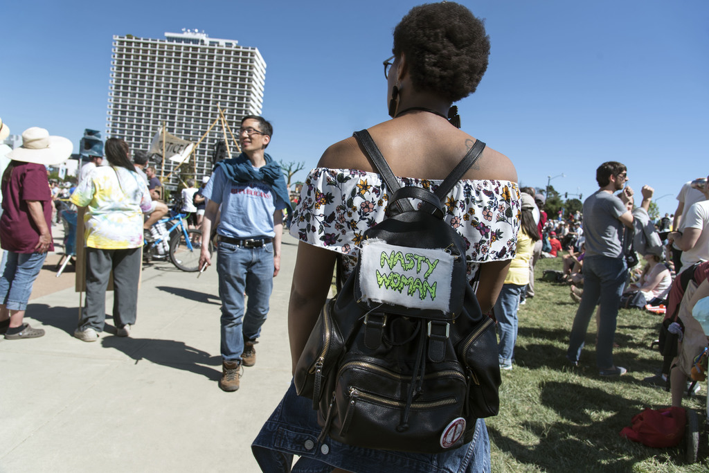A young woman stands in the crowd, her backpack adorned with a "Nasty Woman" patch, at the People's Climate March on April 29, 2017 in Oakland, CA. During the third presidential debate, Donald Trump referred to Hillary Clinton as "such a nasty woman". The phrase went viral, with women across the nation reclaiming it as a rallying cry for women's rights. 