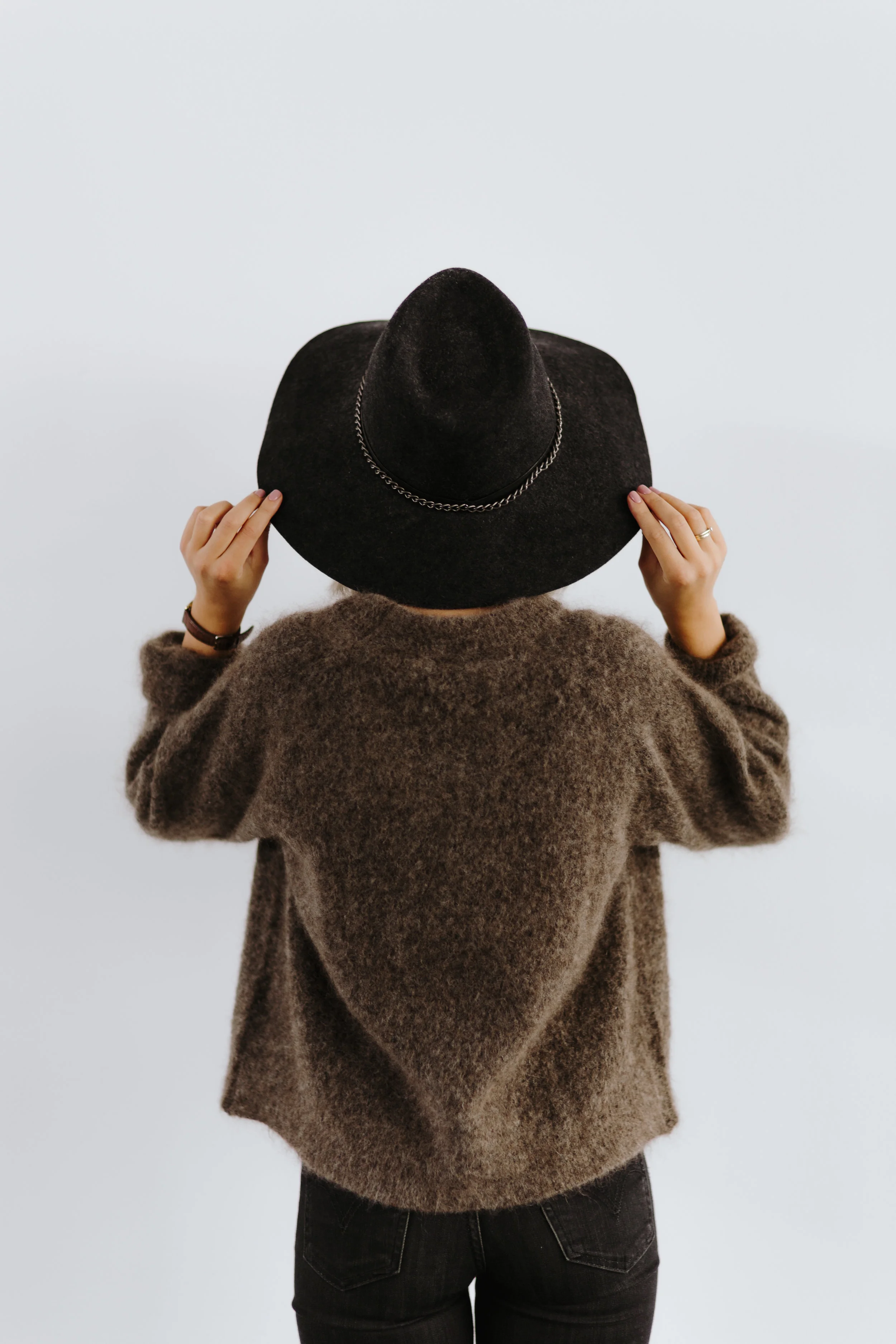 kaboompics_A woman in a brown sweater with a black hat on her head.jpg