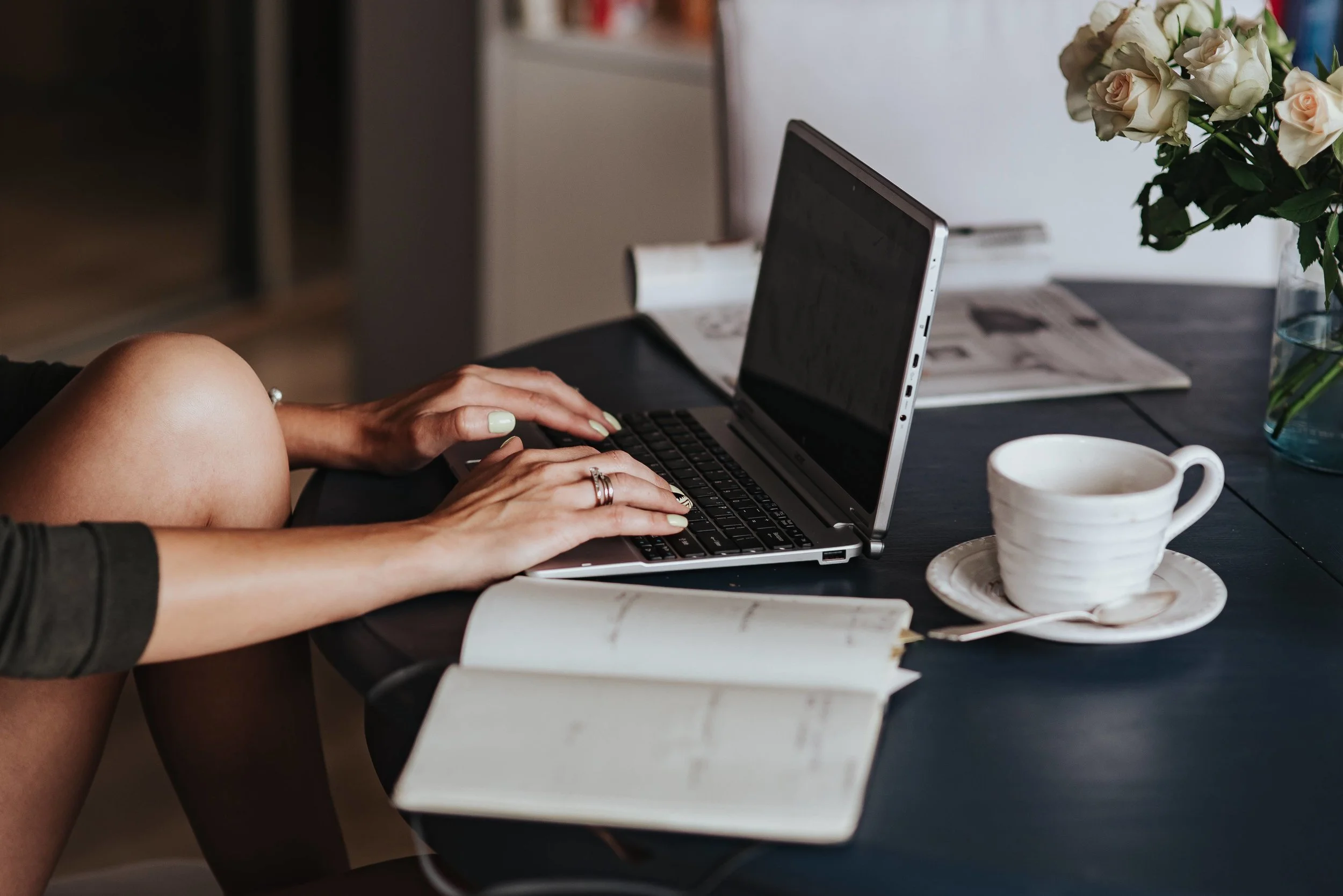 kaboompics_Woman using a laptop by a round breakfast table.jpg