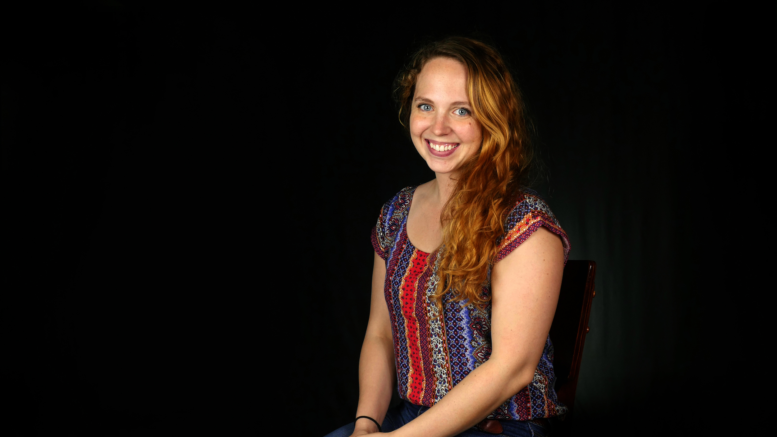 Low key studio photography shoot. We've the subject lit with studio lights and the background is very dark.