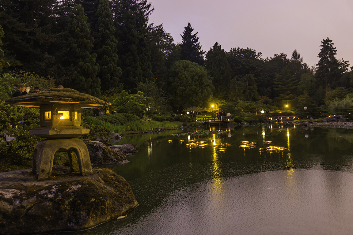 Floating origami boat luminaries placed in the pond by the guests (Photo by SlickPix Photography)