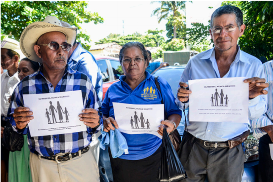 Organizers with signs reading "El Mozote, Never Again"