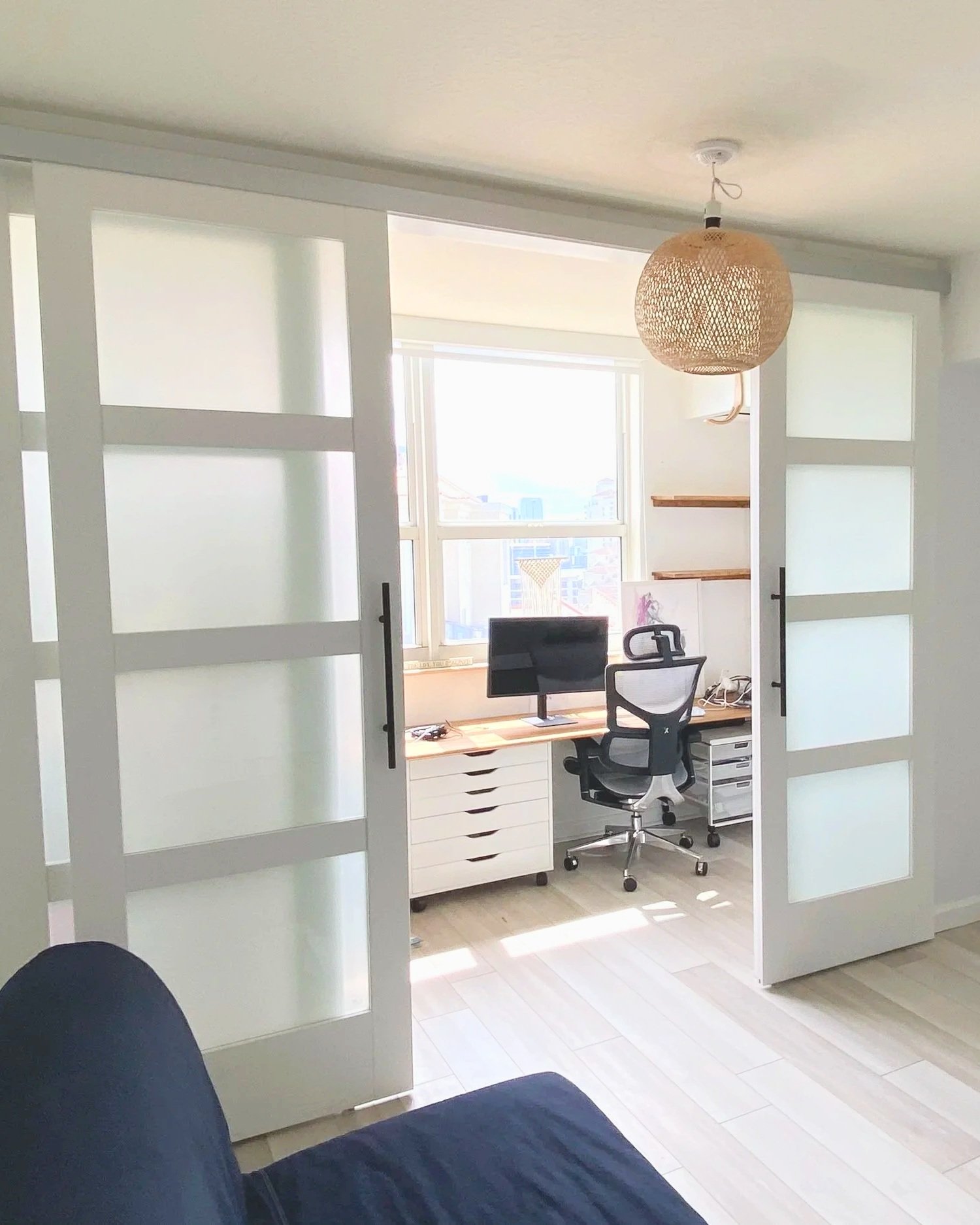 Self-closing, bi-parting door partition creating home office, floating shelves, countertop with rolling office furniture