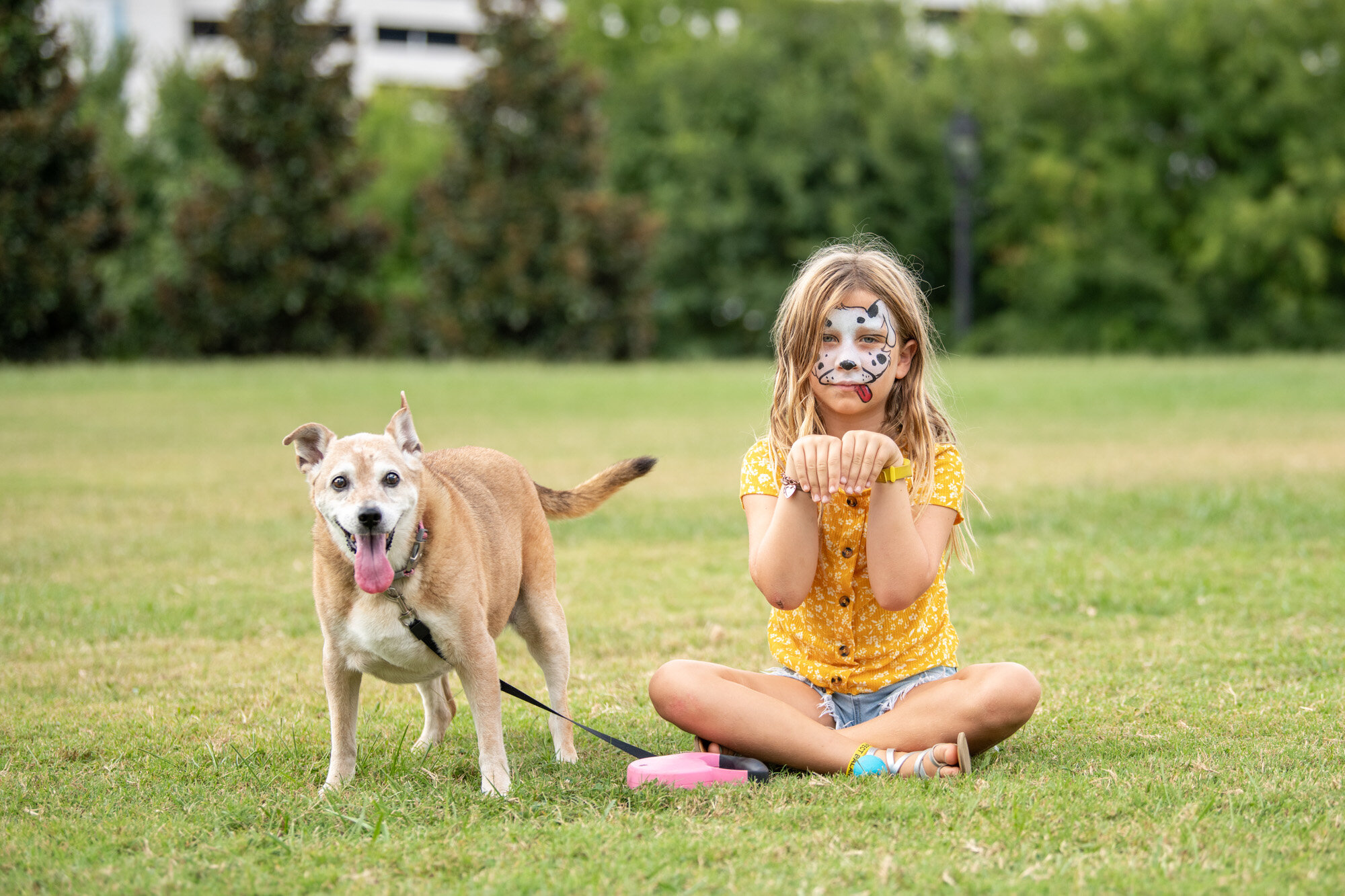face painted young girl with senior dog