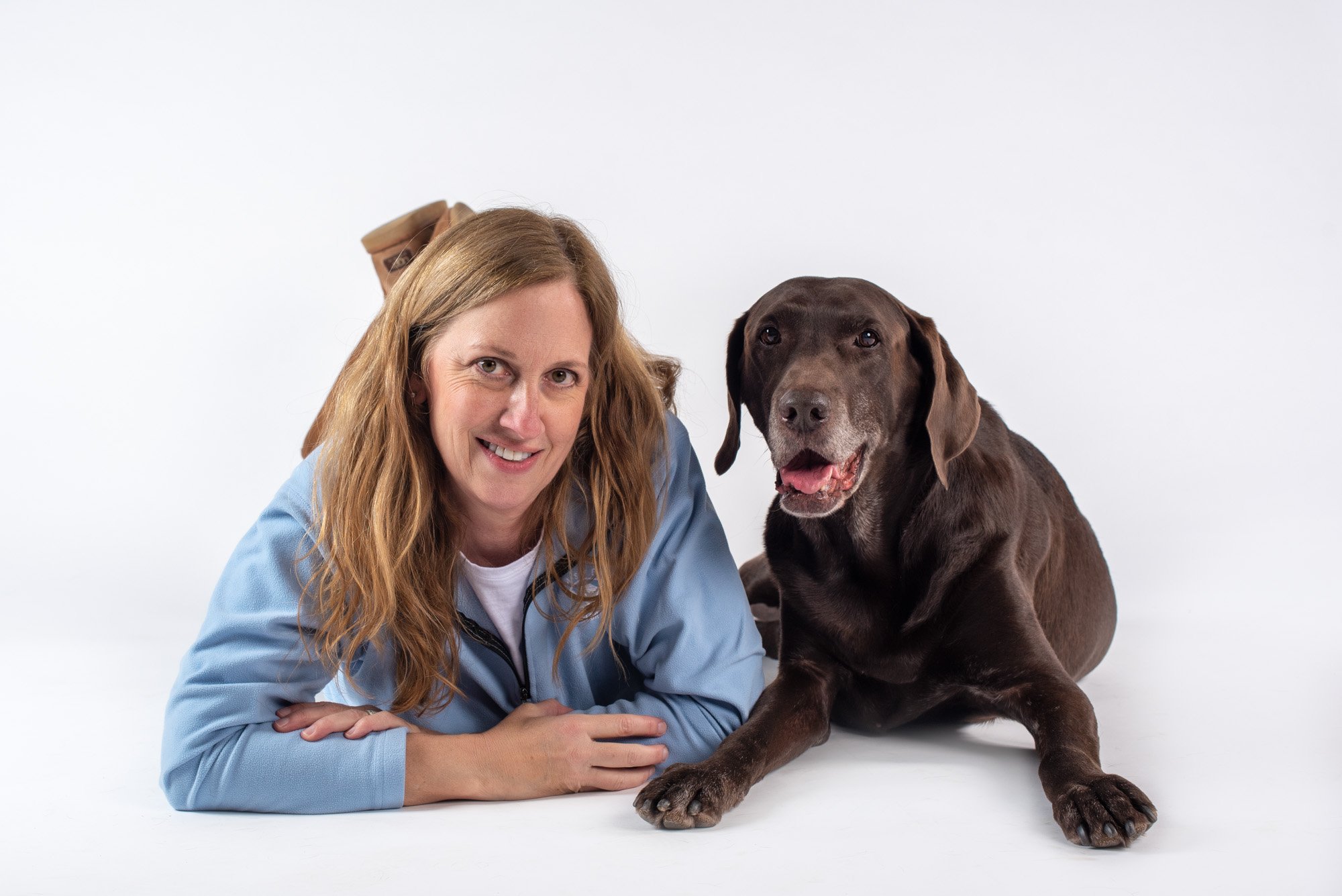 dog photographer Kim Hollis of BARKography posing with her chocolate lab Moose