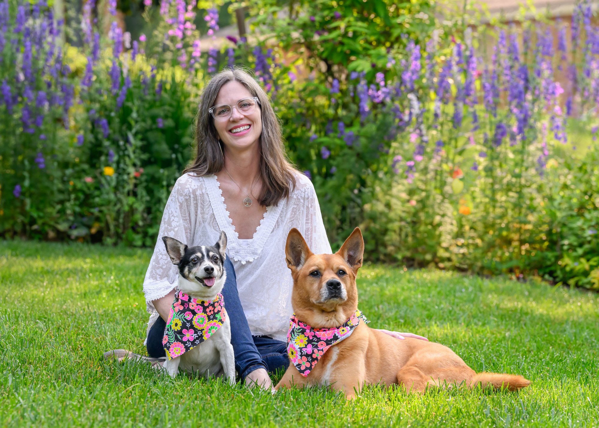 dog mom with 2 senior dogs in front of flowers