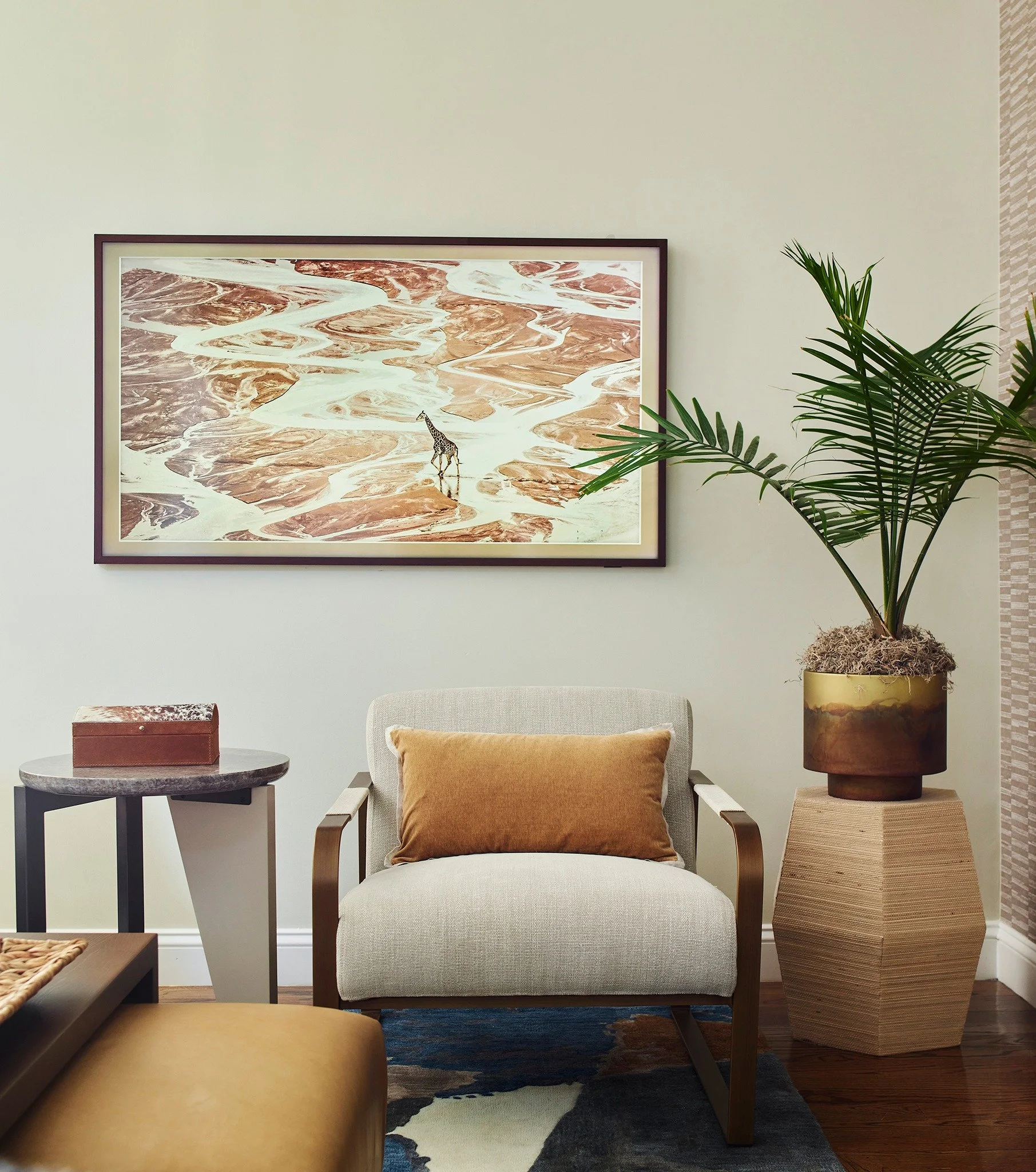 Where art and comfort meet. This layered living space balances global influences with modern ease; brass-framed chairs, sculptural tables, and tonal textures create a grounded yet graphic composition. A reminder that interiors can tell a story withou