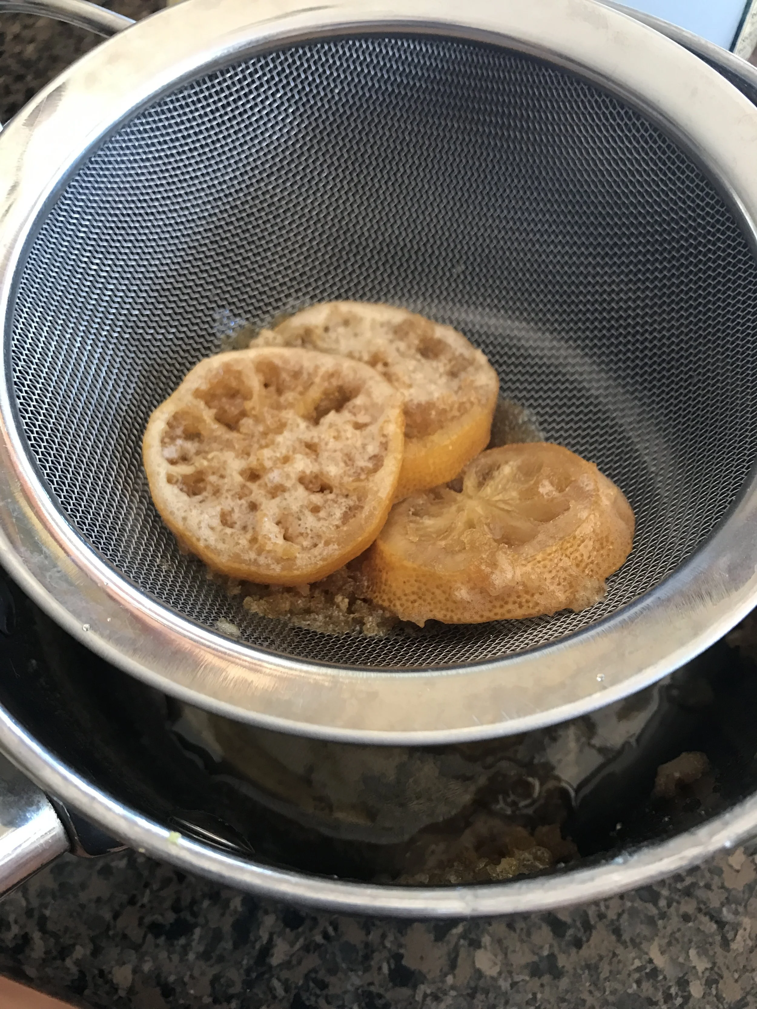 Straining out the zest and lemon slices for a beautiful, clear honey