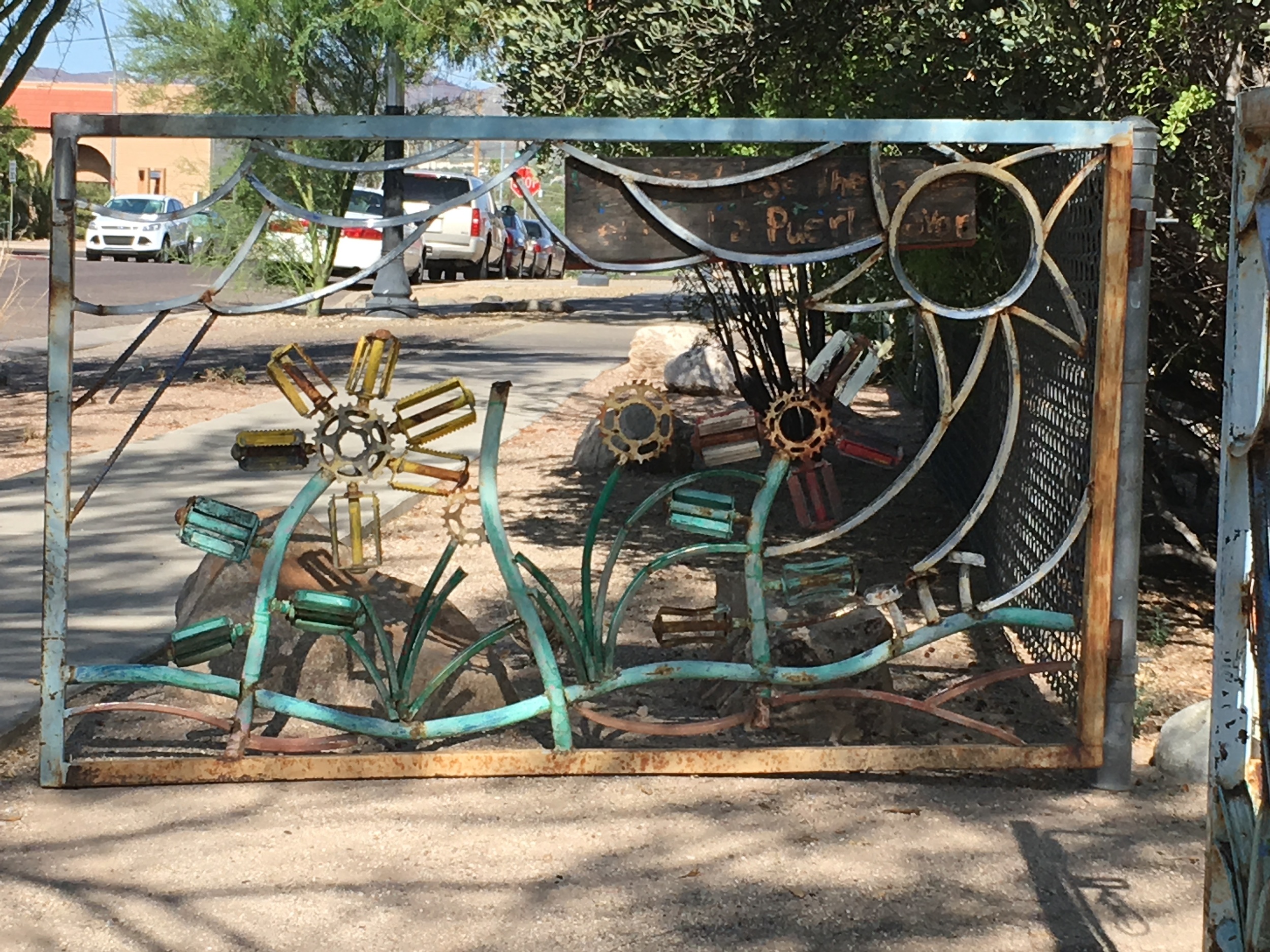 Old bike pedals form the petals and leaves in a gate at the community garden.