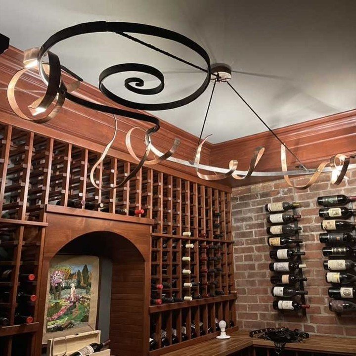 When we say custom made, we mean it! Look how this unique copper and steel chandelier complements this beautiful wine cellar. Connect with us today to commission your very own custom iron work. #coppermetalwork

#ironmountainforge #madeinRI #blacksmi