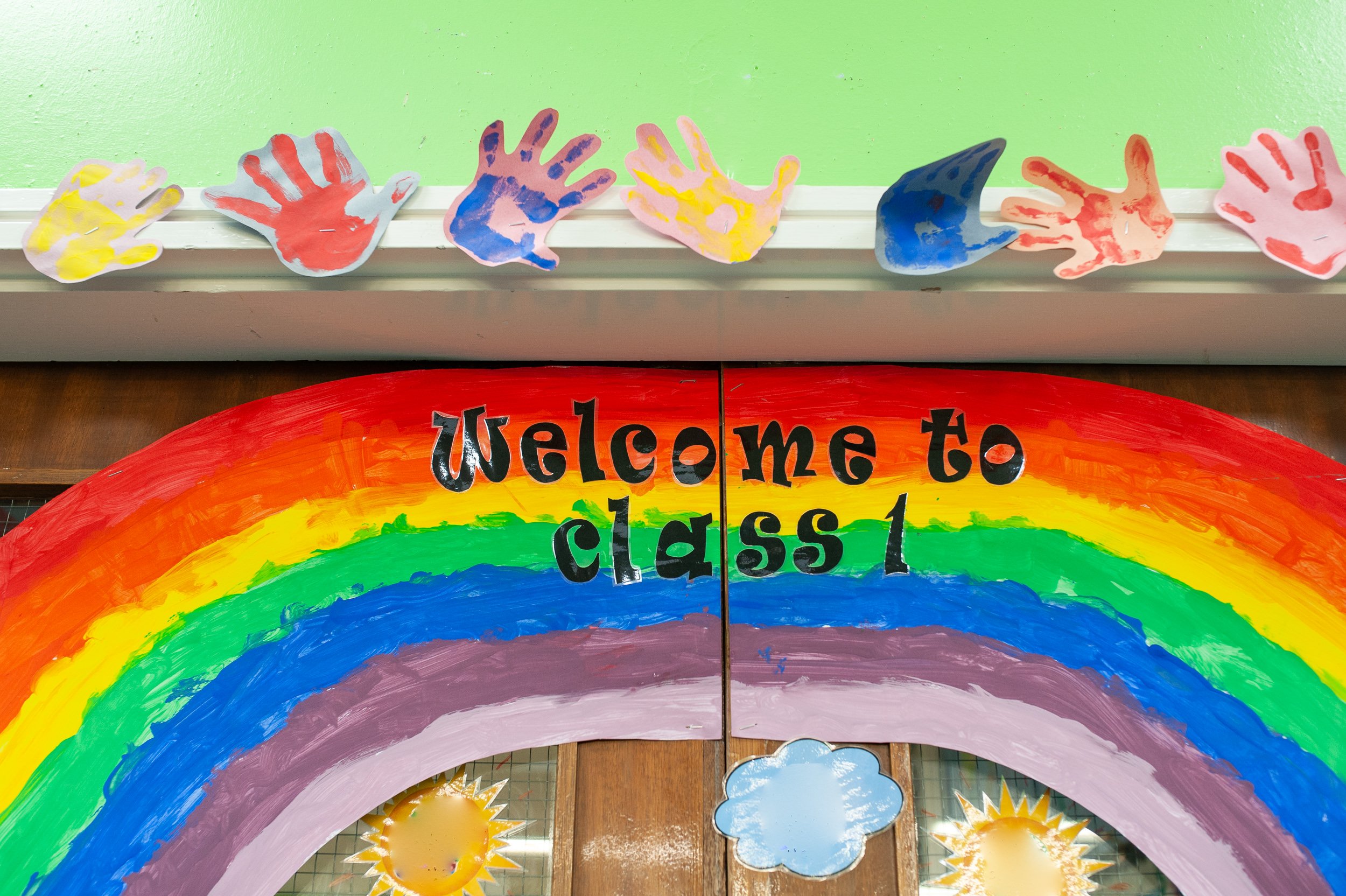 rainbow banner in school, welcome to class 1, above double doors
