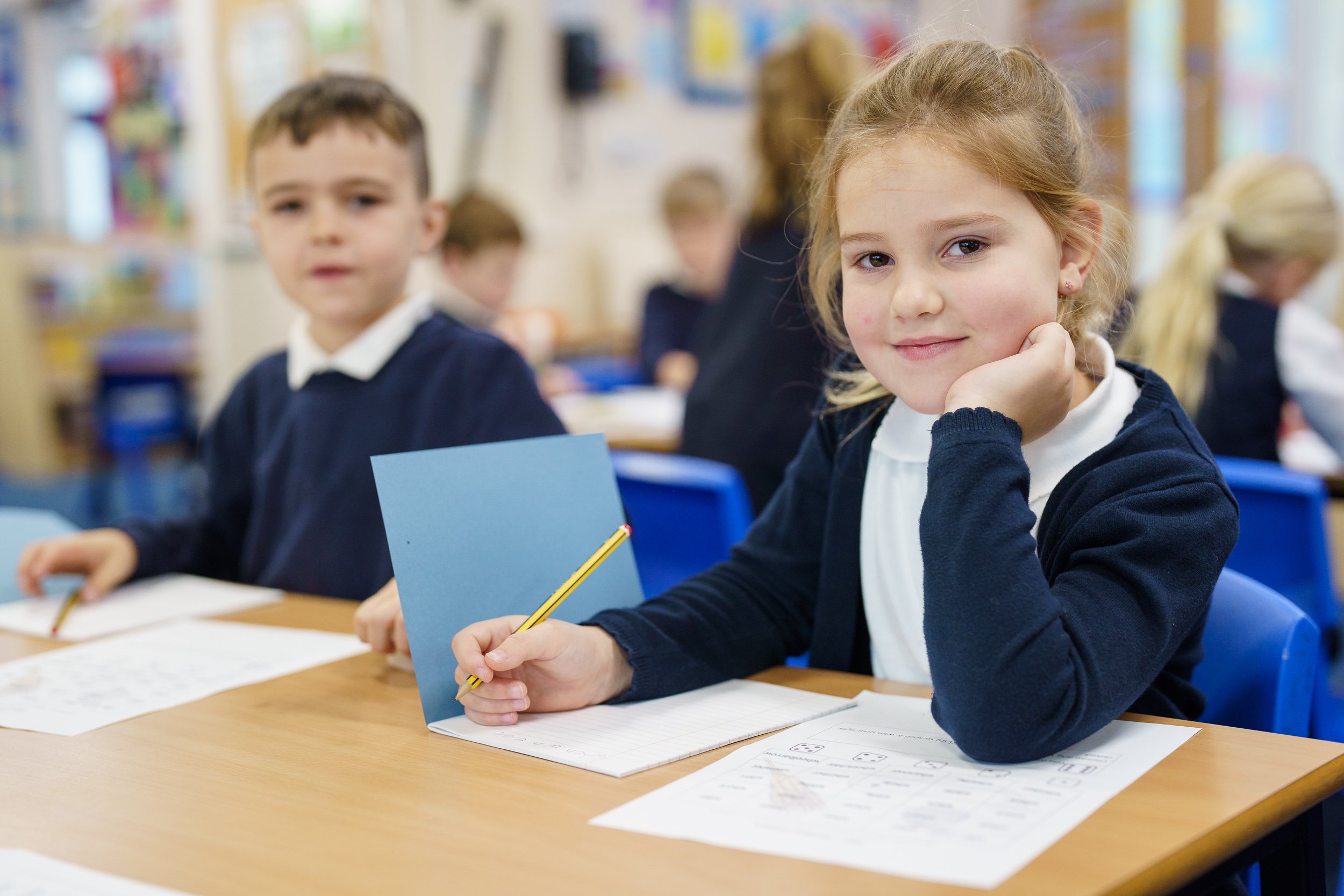 pupils writing in books at desks in manchester primary school