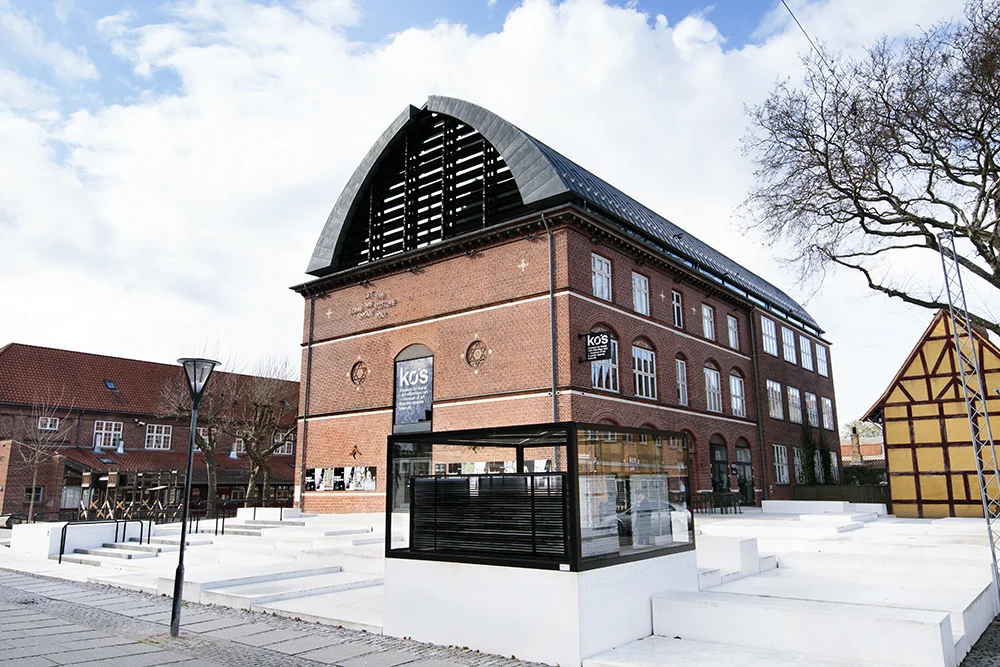 KØS - Museum for Kunst i det offentlige rum "KØS er Danmarks og et af verdens eneste museer for kunst i det offentlige rum. Museet beskæftiger sig i udstillinger, forskning og formidling med de helt særlige udfordringer og muligheder, som kunsten møder i det offentlige rum, og fortæller fascinerende kunsthistorie, der knytter sig til dette virkefelt for kunsten – fra konge og kirke til nutidens velfærdssamfund, hvor kunsten bl.a. integreres på offentlige institutioner og som motor for byudvikling." Adresse: Nørregade 29, 4600 Køge. Links: Koes.dk | Læs mere på idoart.dk Foto: I DO ART Agency, 2017.