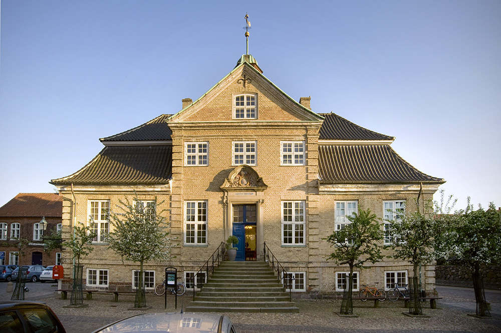 Skovgaard Museet "Skovgaard Museet er kunstmuseet i Viborg. Museet er en arkitektonisk perle midt i Viborgs ældste bydel og har til huse i byens gamle rådhus fra 1728. Her ved siden af Viborgs Domkirke mødes flere generationer af kunstnerslægten Skovgaard. Skovgaard Museet perspektiverer sine samlinger med særlige udstillinger, der beriger og nuancerer kunsten." Adresse: Domkirkestræde 2-4, 8800 Viborg. Links: Skovgaardmuseet.dk | Læs mere på idoart.dk Foto: Ole Misfeldt og Skovgaard Museet.