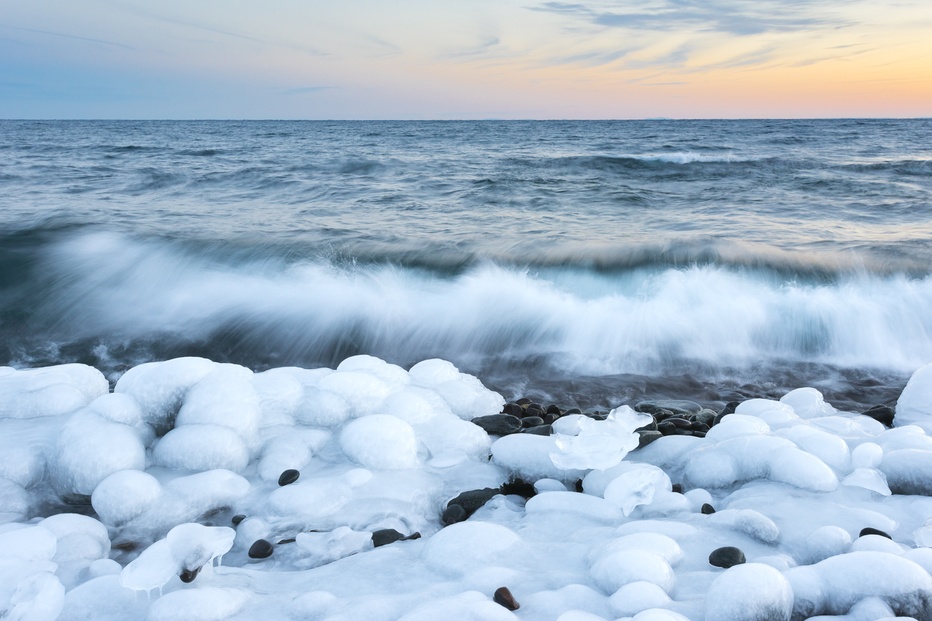 Ice-encased beach rocks and December surf.