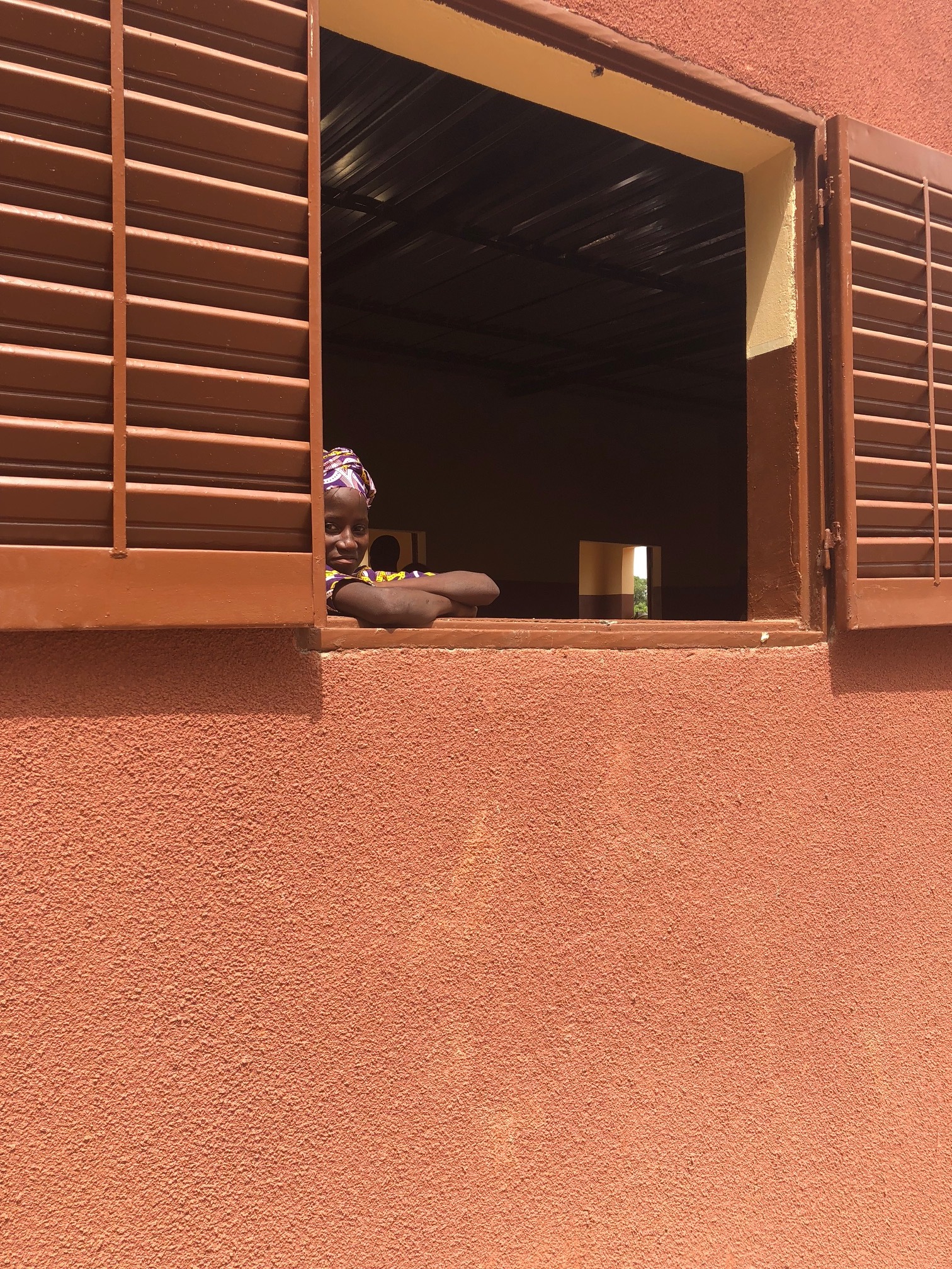 An eighth grader peeks out from her new classroom.