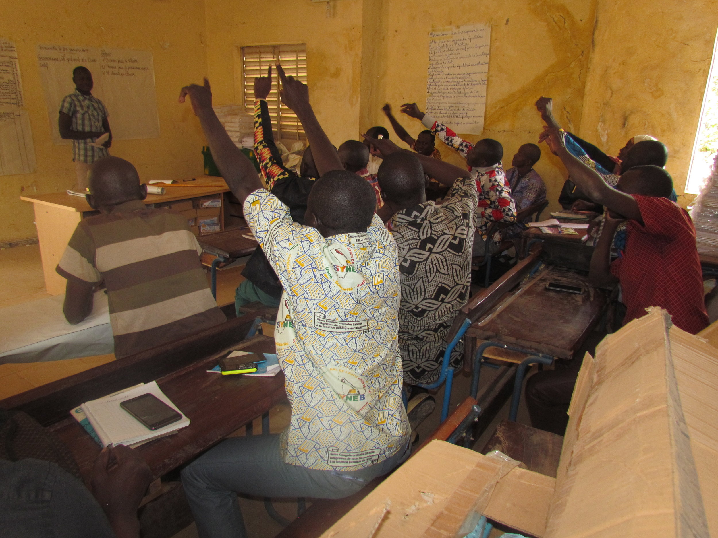 A French teacher presents his lesson while other teachers play student.