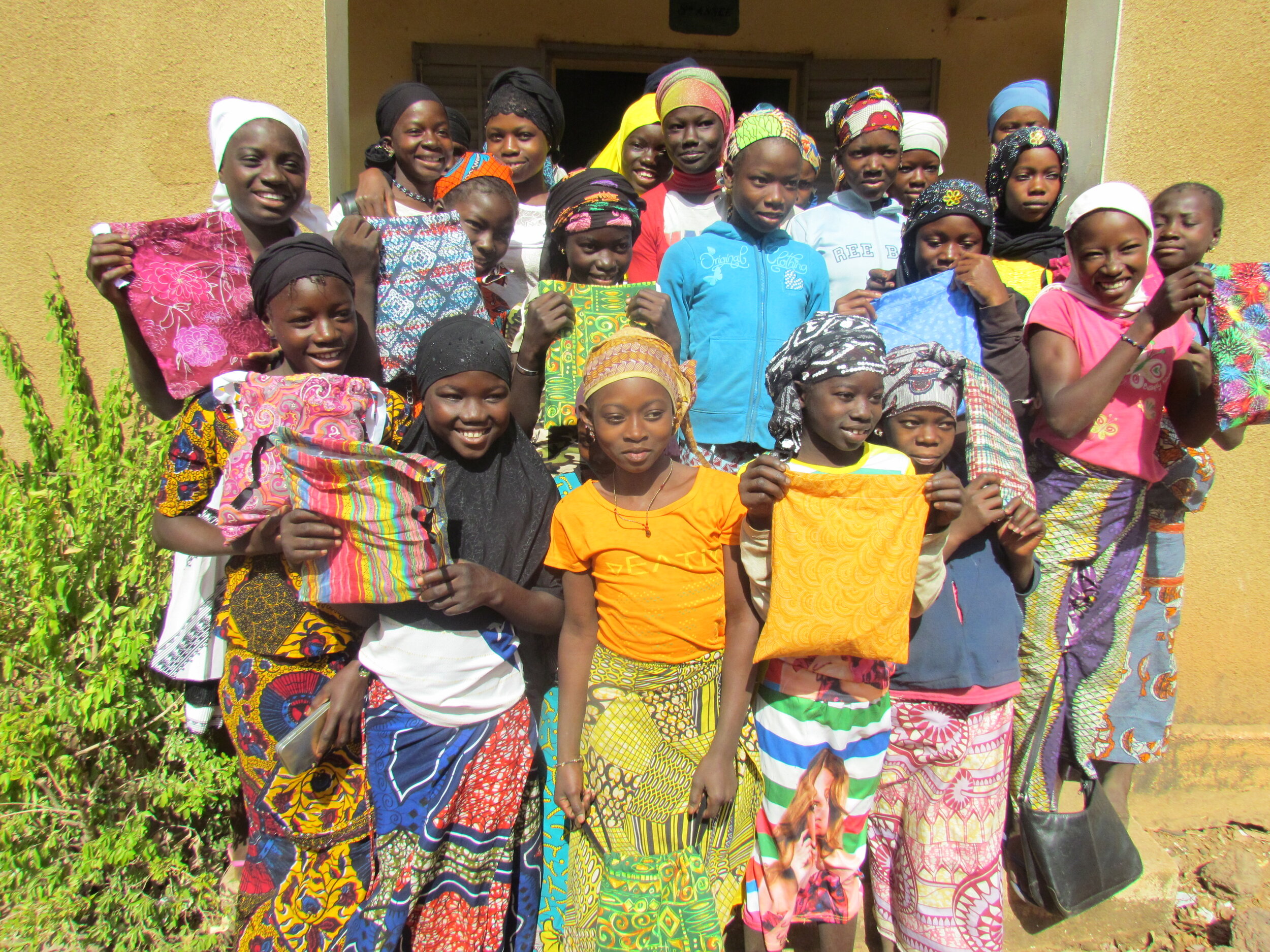 Girls show off their new menstrual kits.