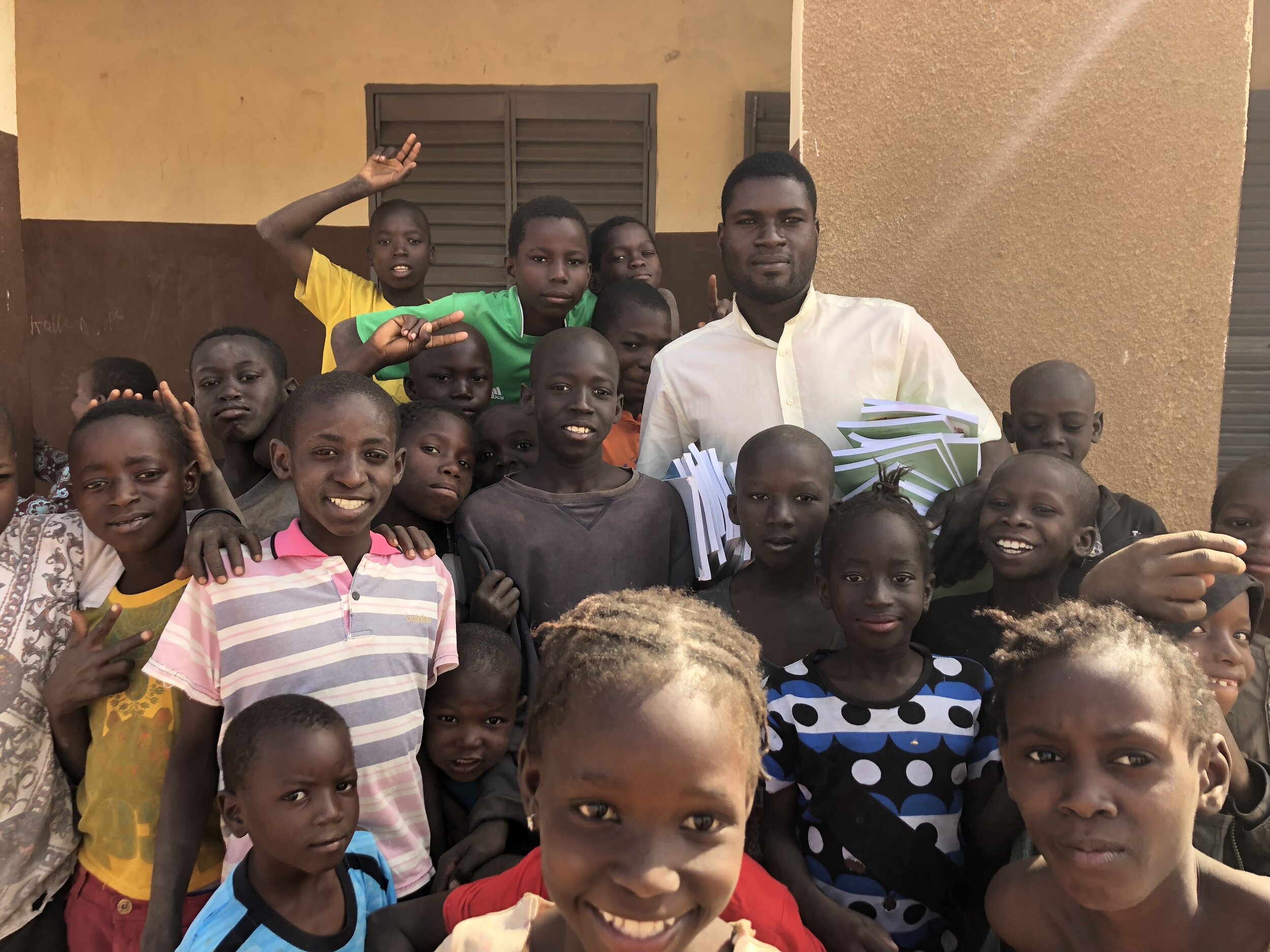 A teacher and his students celebrate the arrival of new textbooks.