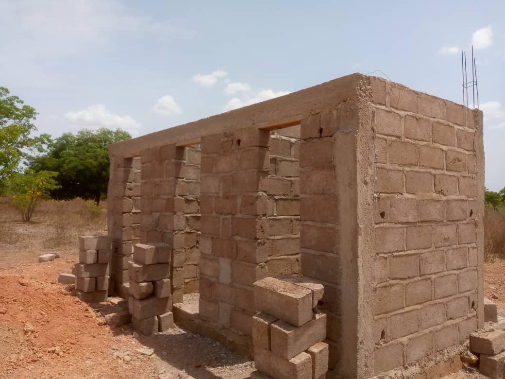 One of two latrine blocks rises over the pits.