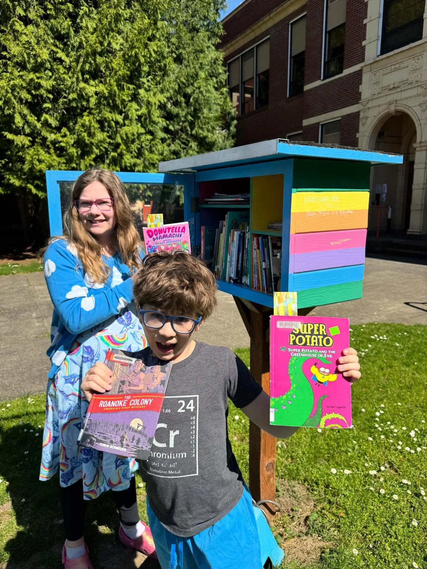 FRIENDS OF THE LIBRARY YOUTH ADVOCATES (ADA &amp; CHARLIE) DELIVERING BOOKS TO THE LITTLE FREE LIBRARY AT BUCKMAN ELEMENTARY.