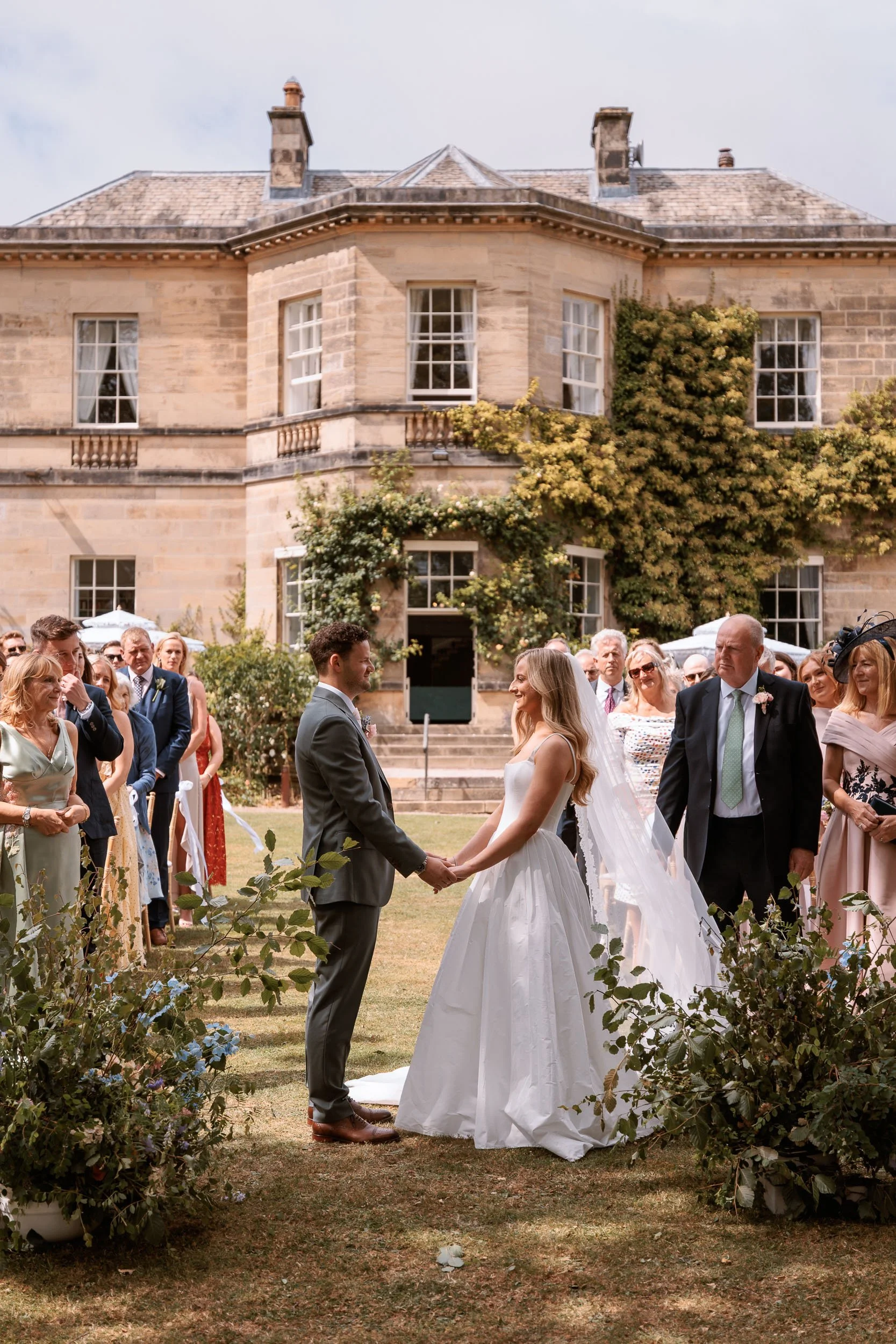 Newlyweds surrounded by guests outside Middleton Lodge Main House.