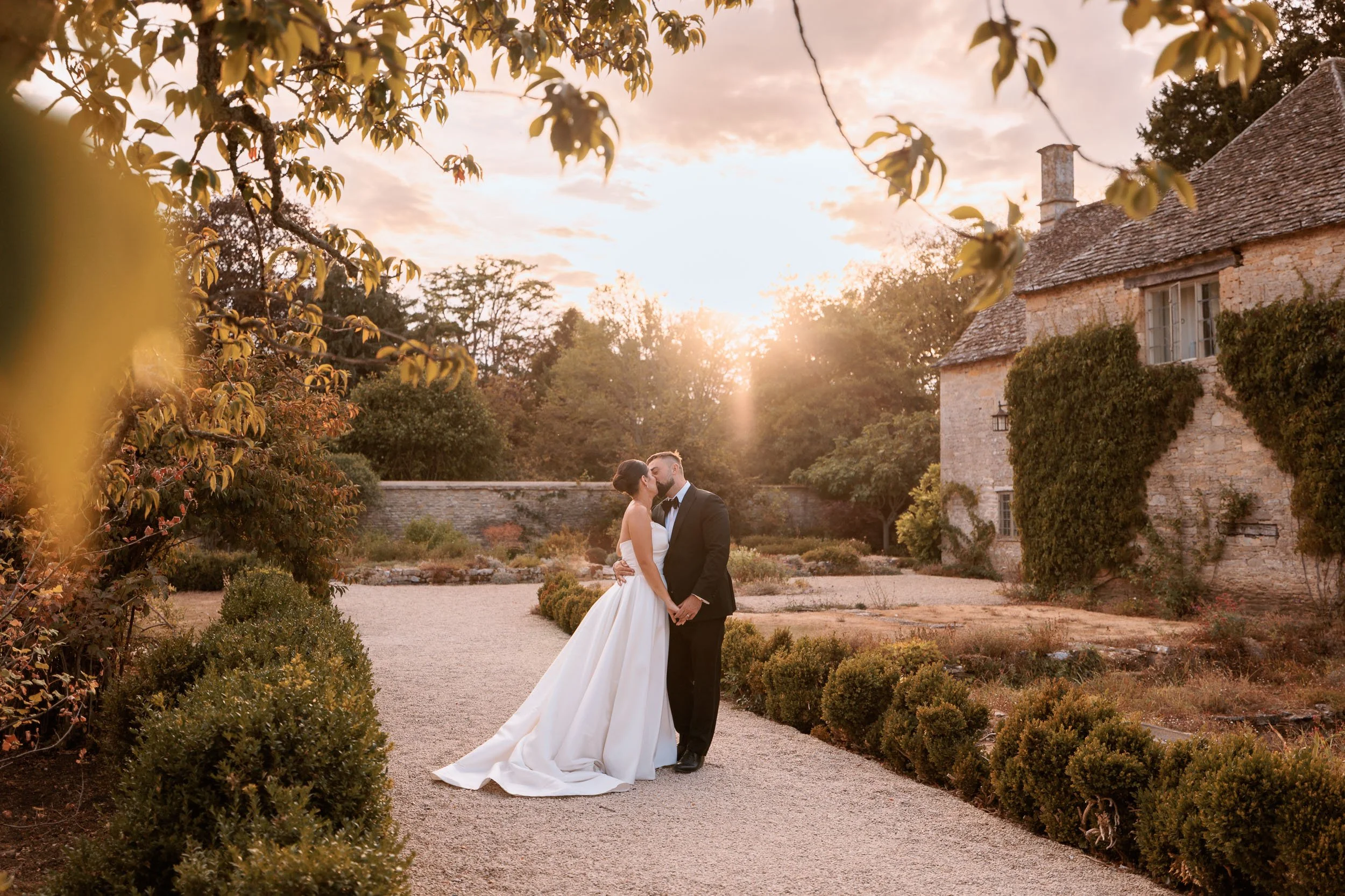 Golden-hour wedding portrait of a couple in the grounds of Caswell House, Oxfordshire.