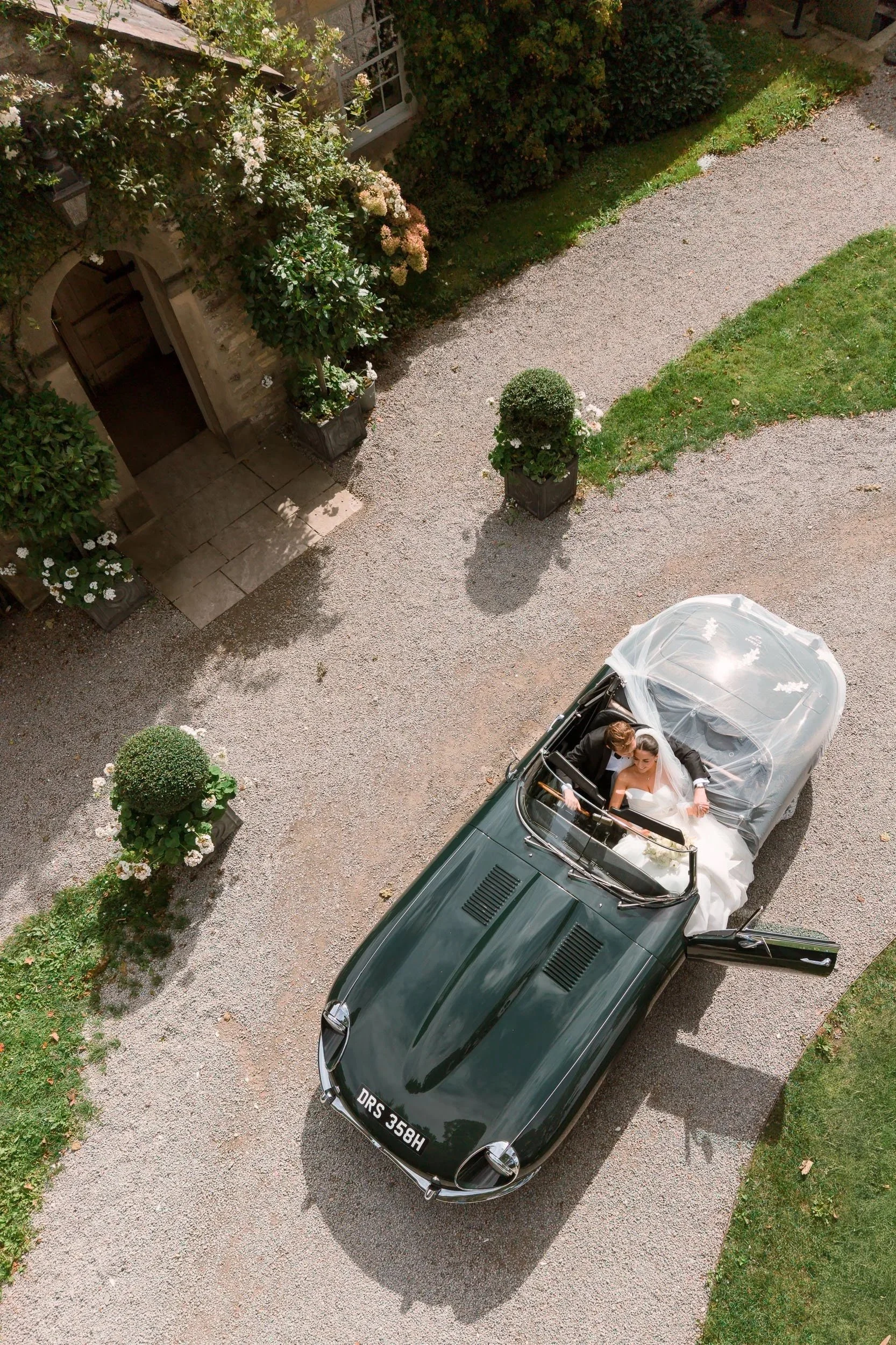 Aerial view of a vintage wedding car arriving at Middleton Lodge.