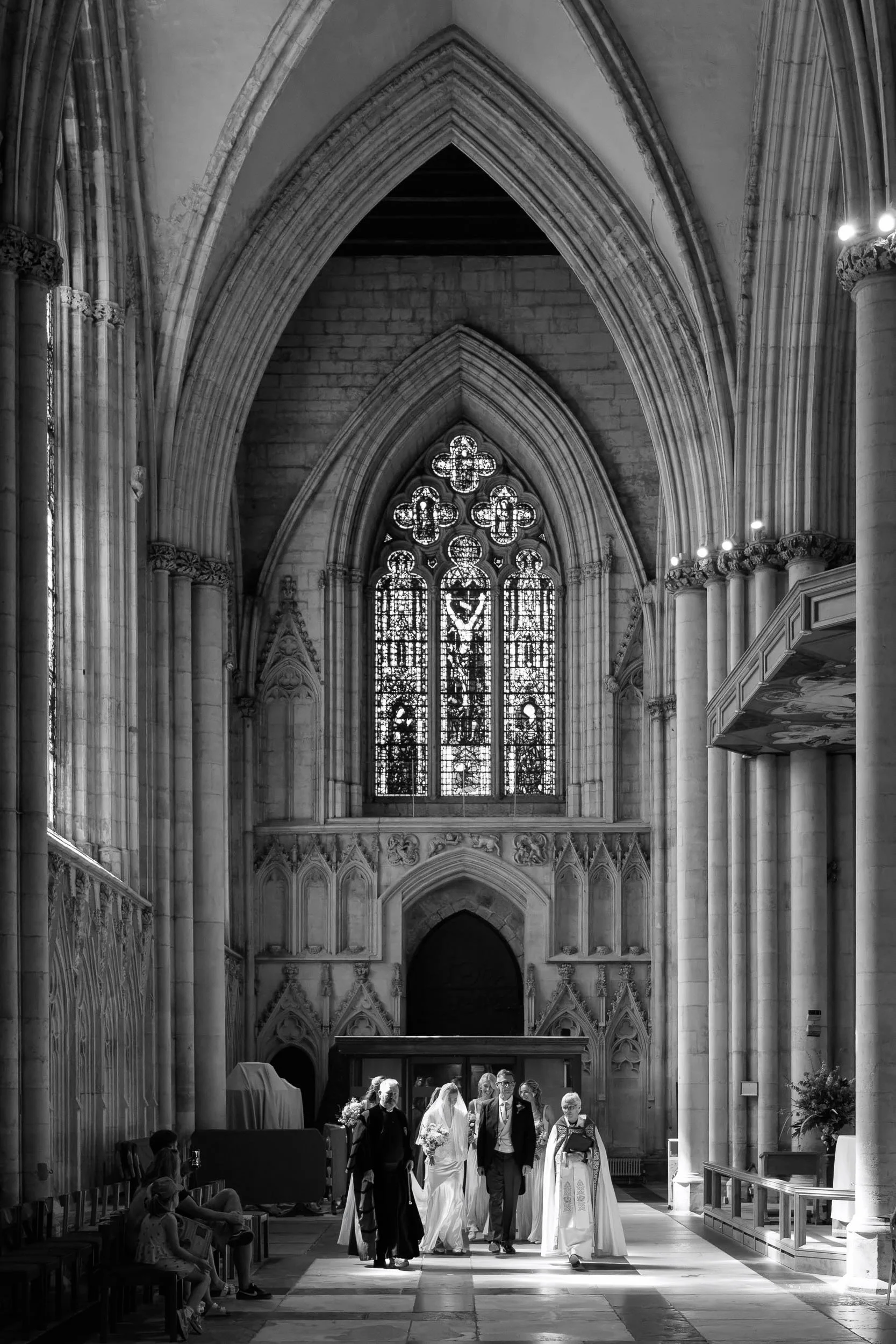 Wedding procession framed by the historic architecture inside York Minster.