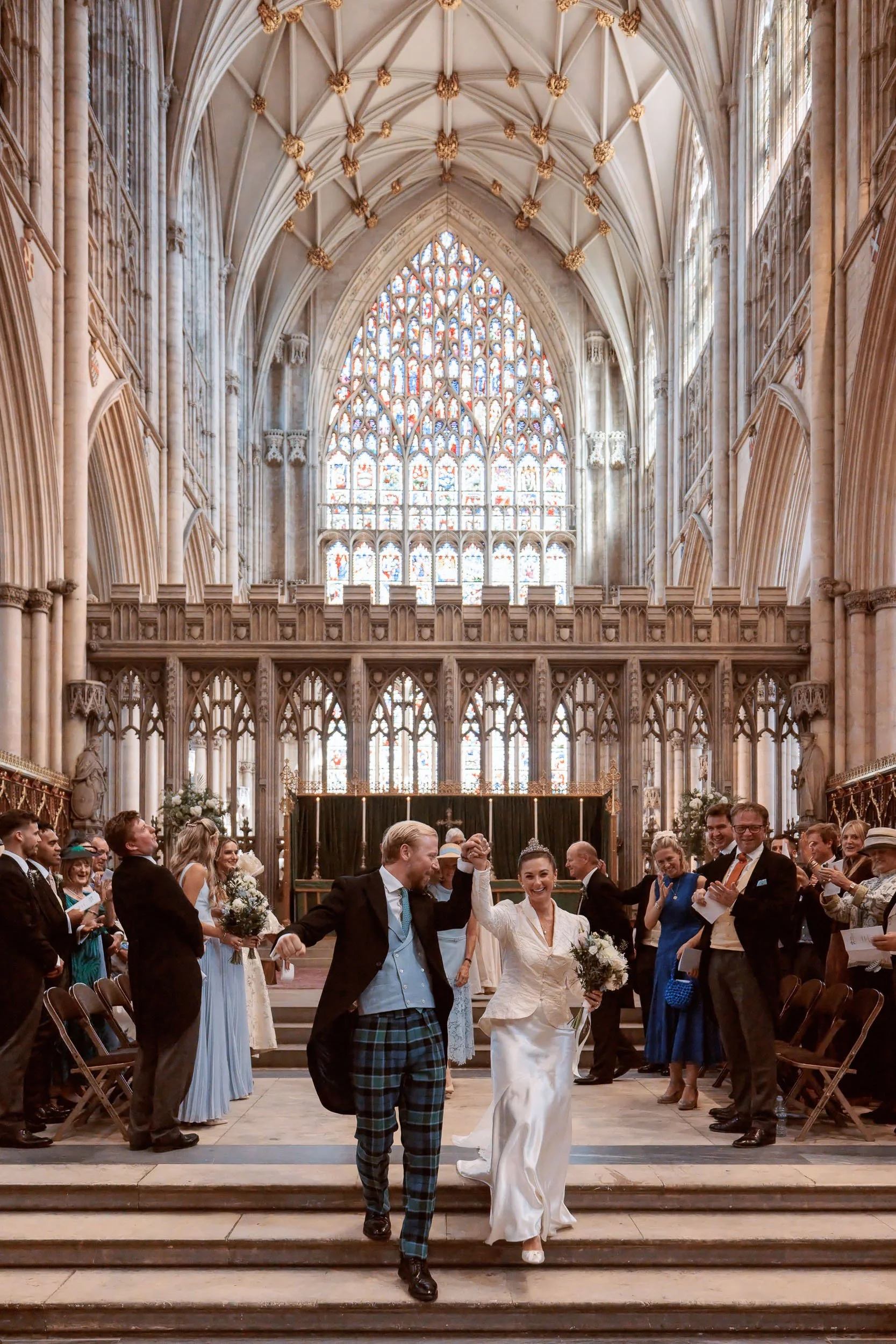 Alicia and Max walking back through York Minster after their wedding ceremony.