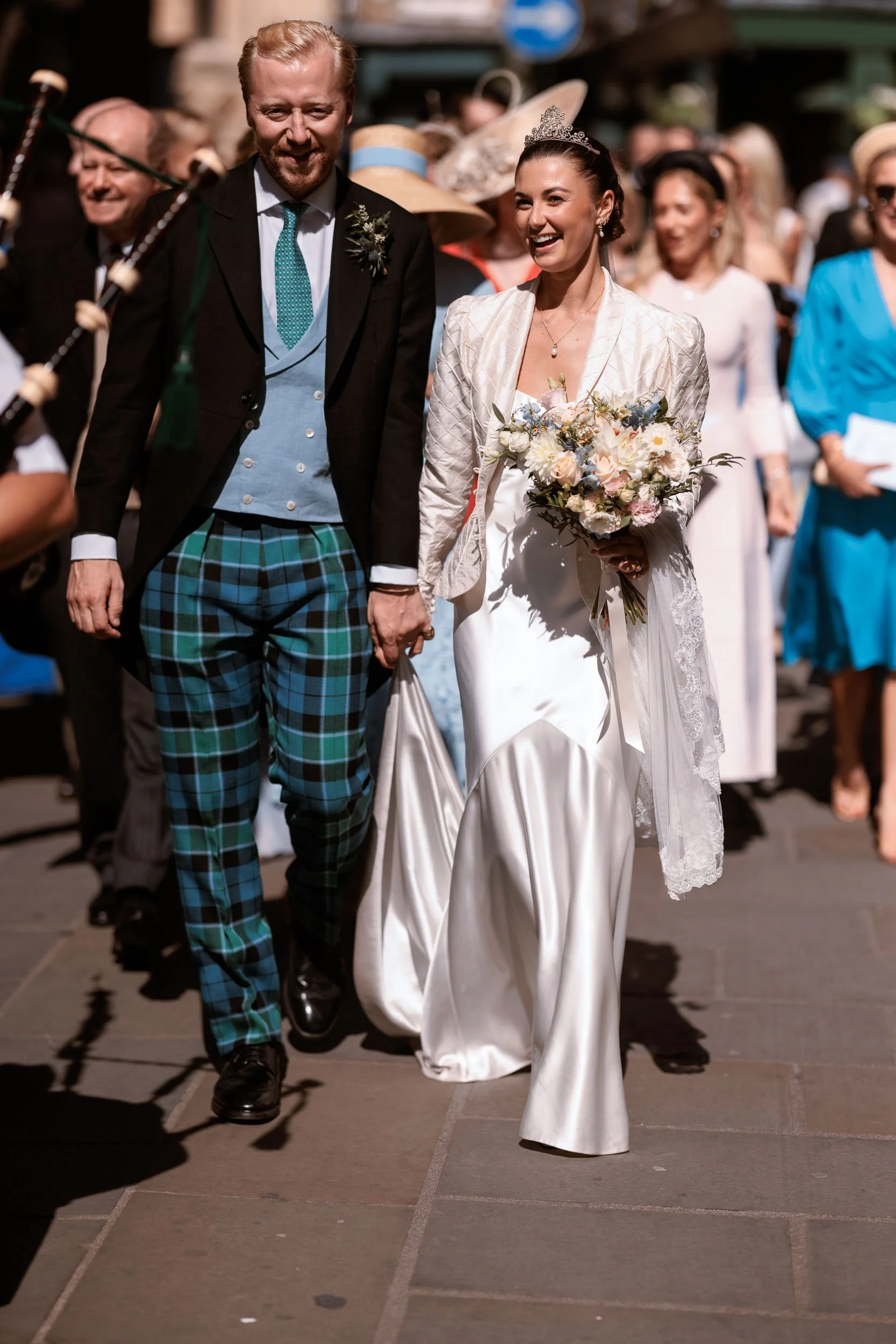 Alicia and Max walking together through their wedding guests after the ceremony.
