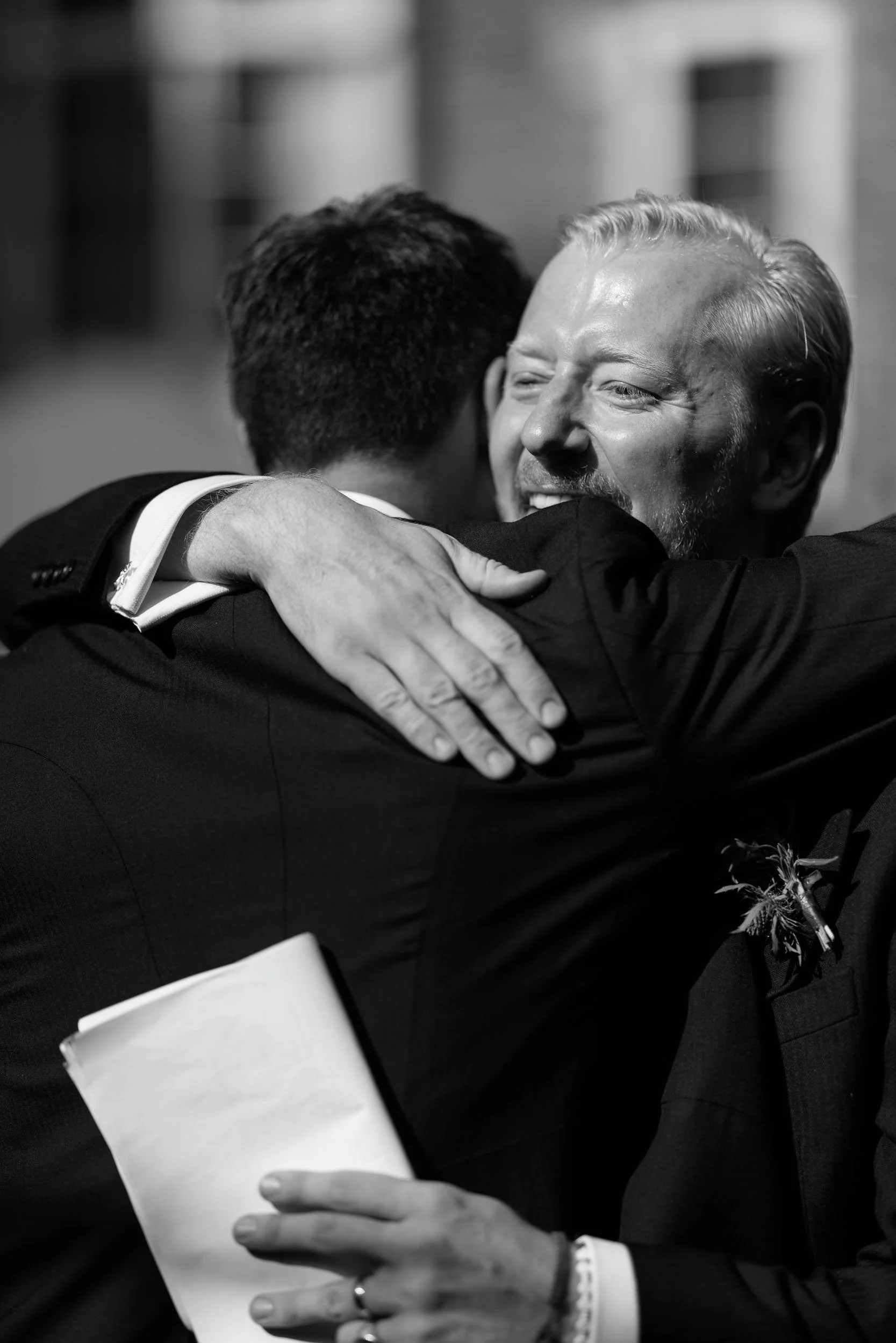 Black and white photograph of Alicia and Max embracing during their reception.