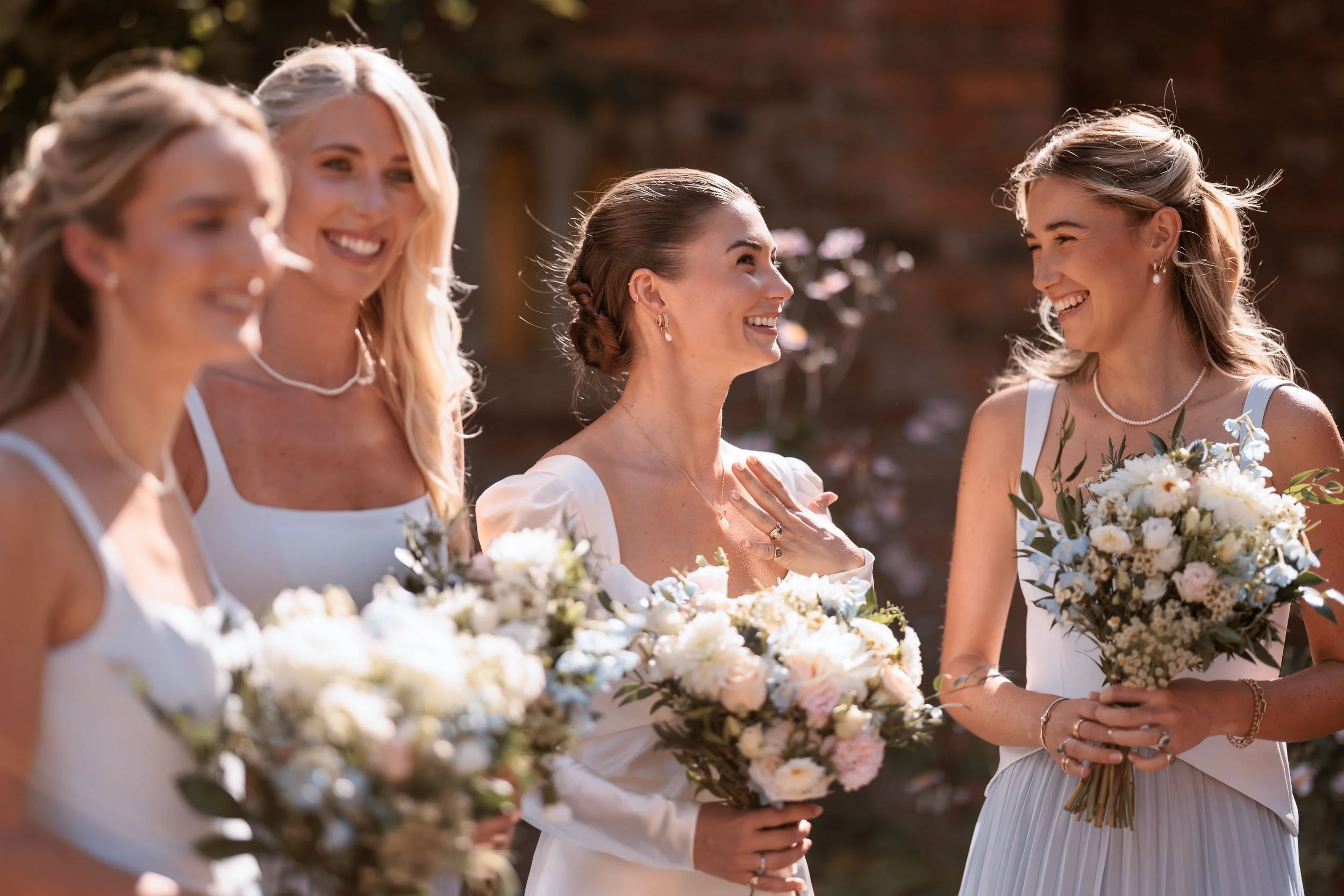 Alicia laughing naturally with her bridesmaids during the wedding celebrations.
