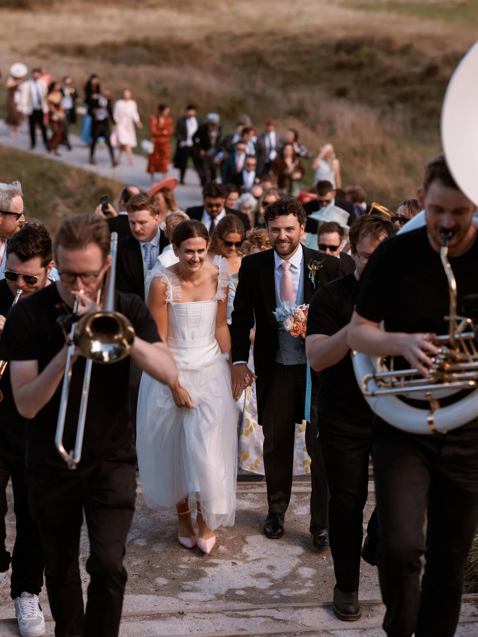 Lucy &amp; Chris married at the historic Bolton Priory, followed by celebrations at Tithe Barn - with one of the best journeys between ceremony and reception! The whole wedding party walked from the Priory to Tithe Barn in procession, led by the bril