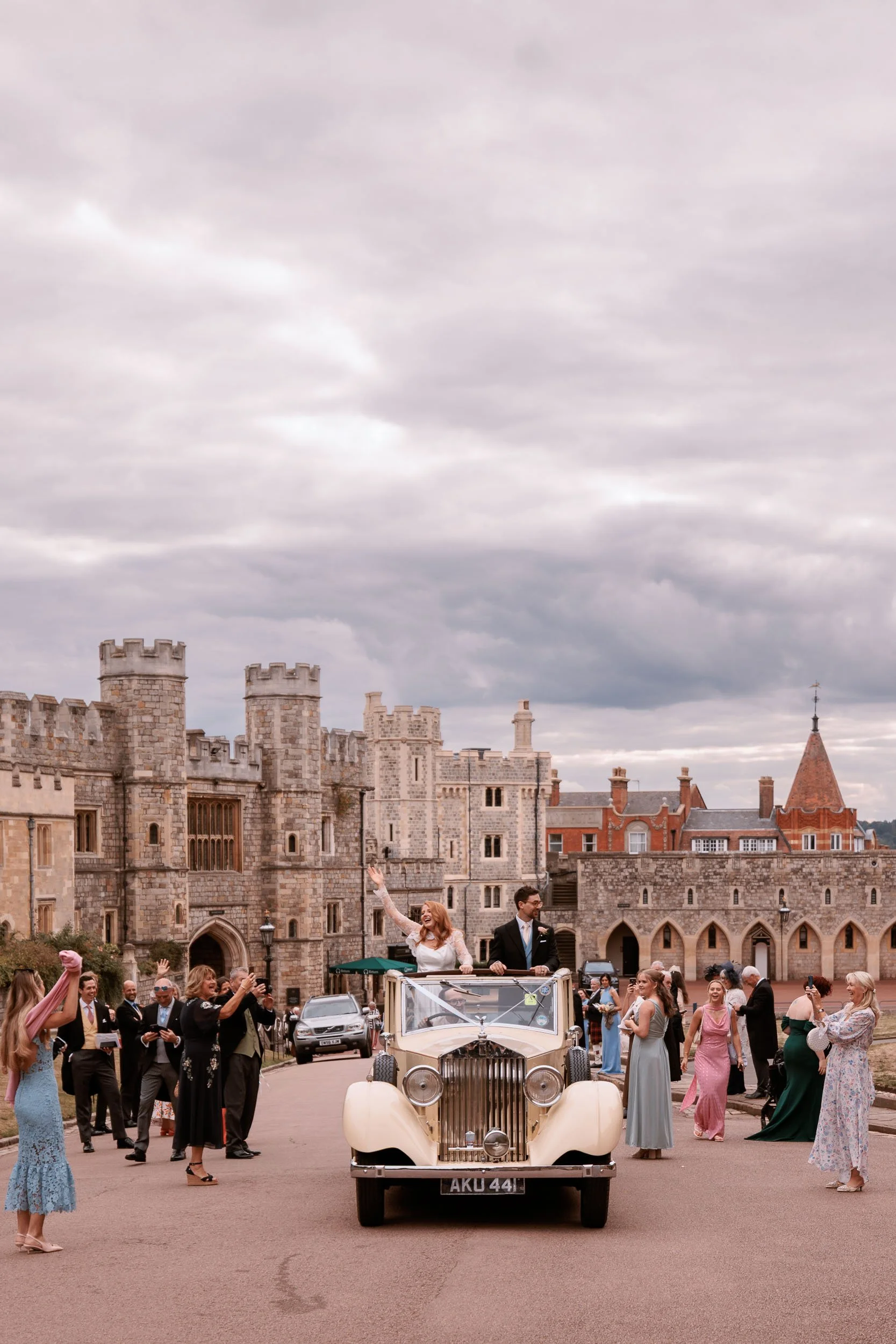Clemmie and James inside their wedding car with Windsor Castle behind them
