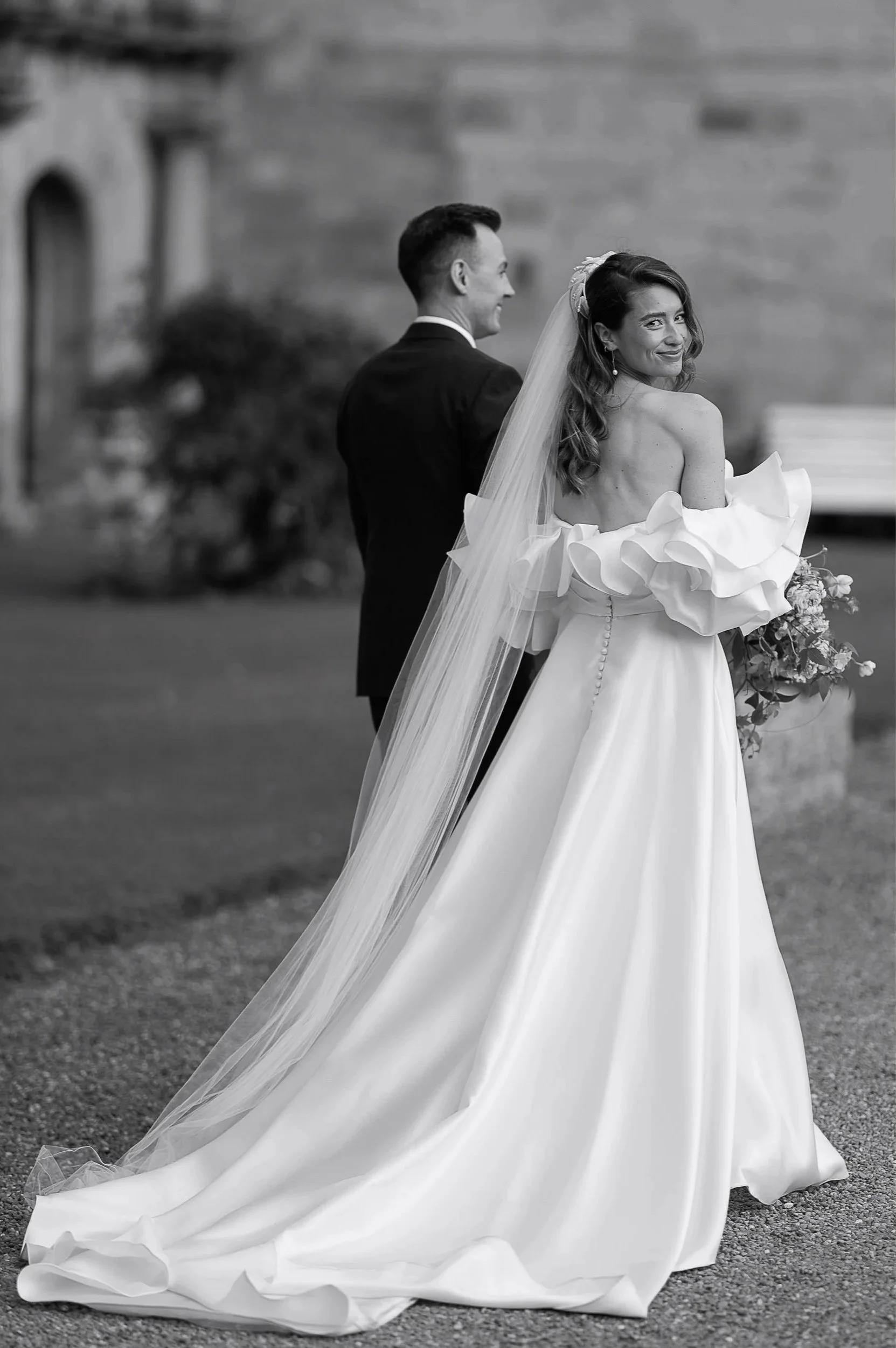 Bride smiling over her shoulder during an elegant Yorkshire wedding, photographed in an editorial style by Neil Jackson.