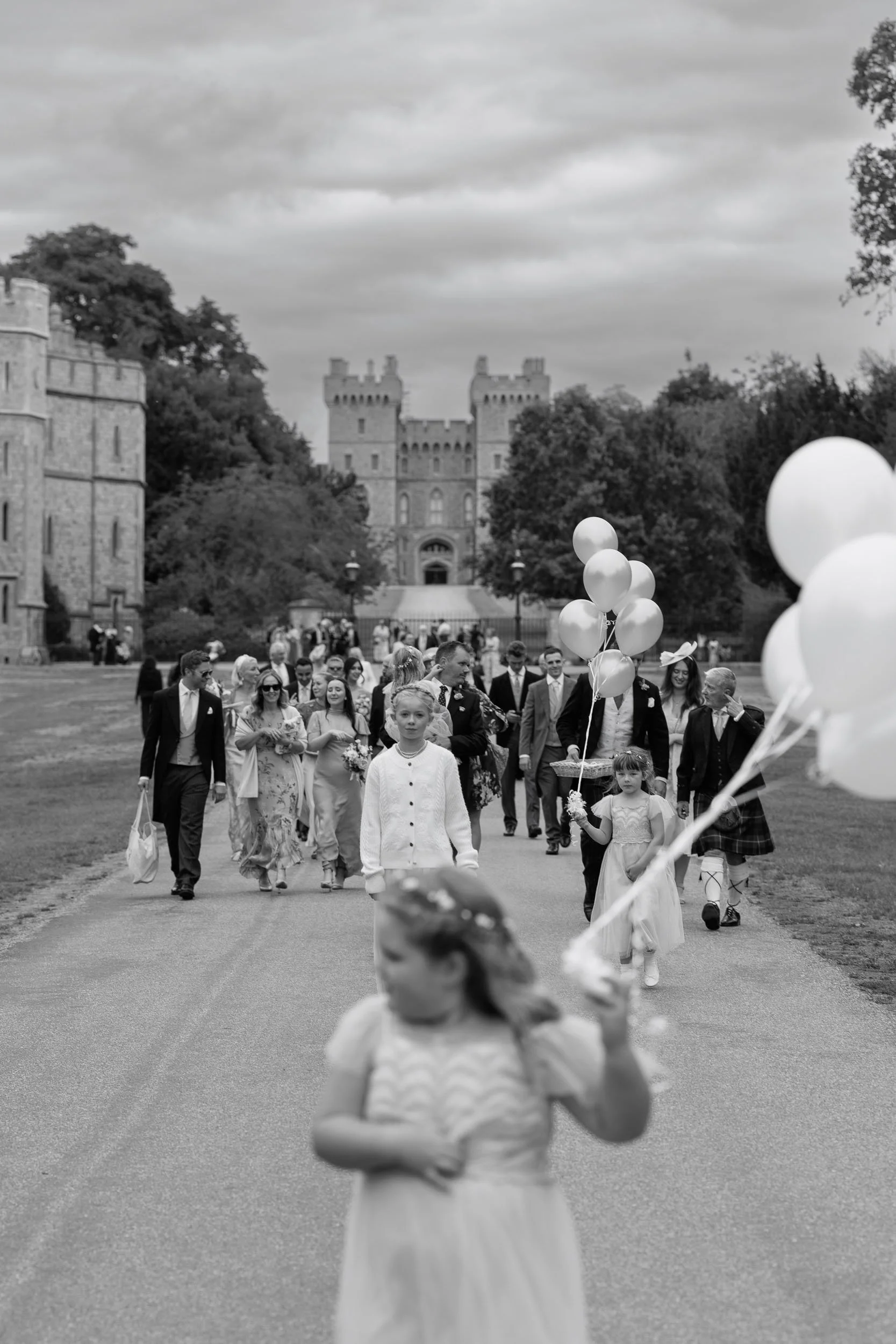 Wedding party and guests walking through the grounds of Windsor Castle