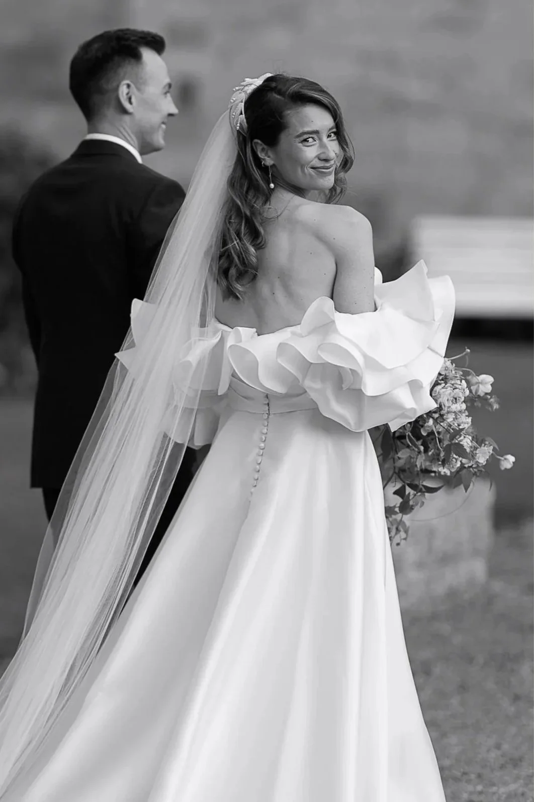 Bride smiling over her shoulder during an elegant Yorkshire wedding, photographed in an editorial style by Neil Jackson.