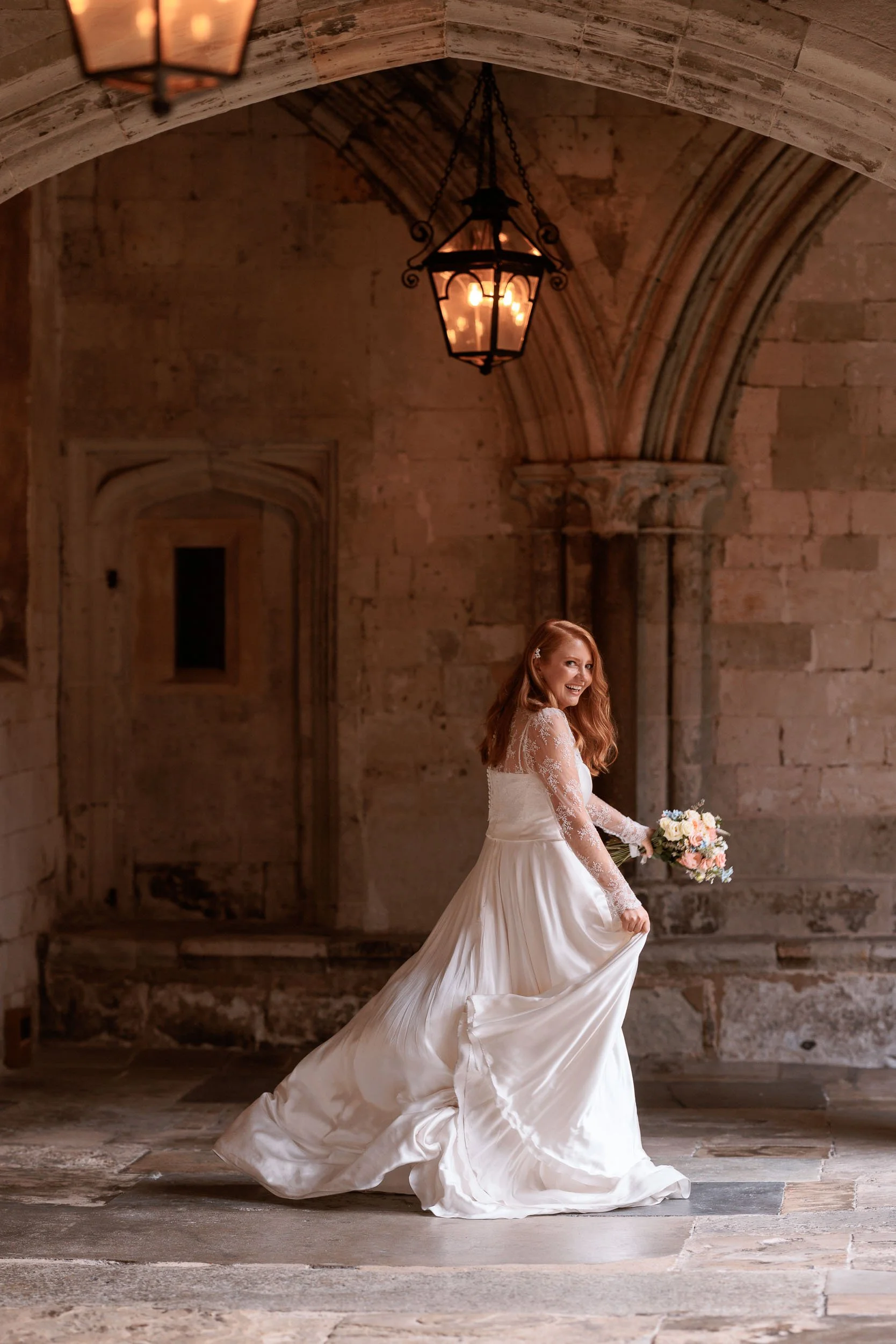 Clemmie walking beneath the historic stone arches of the Windsor Castle cloisters