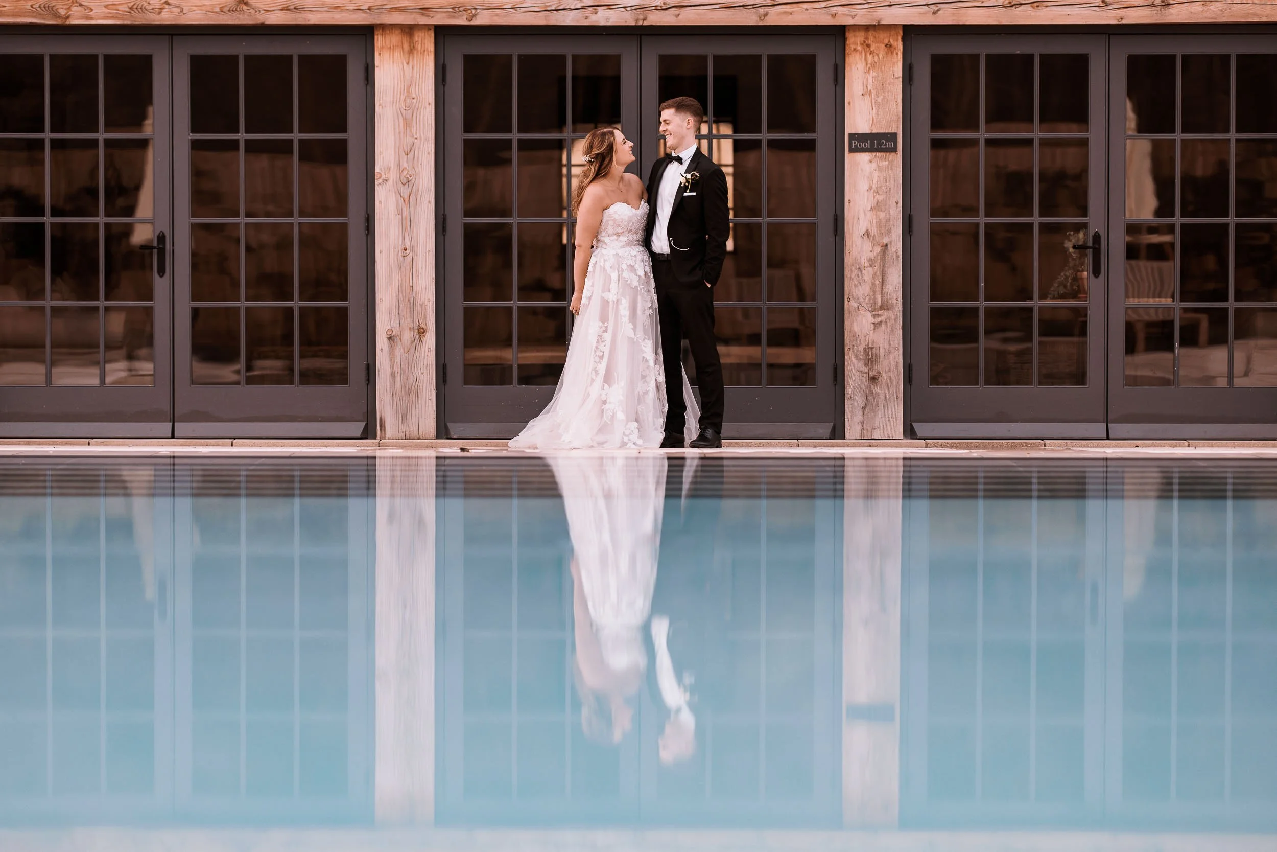 Newlyweds reflected beside the outdoor pool at Middleton Lodge.