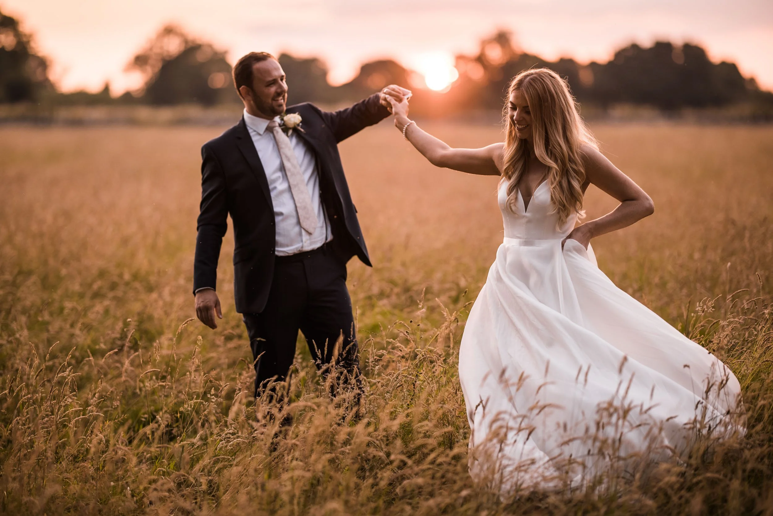Newlyweds walking together through the grounds at sunset at Middleton Lodge.