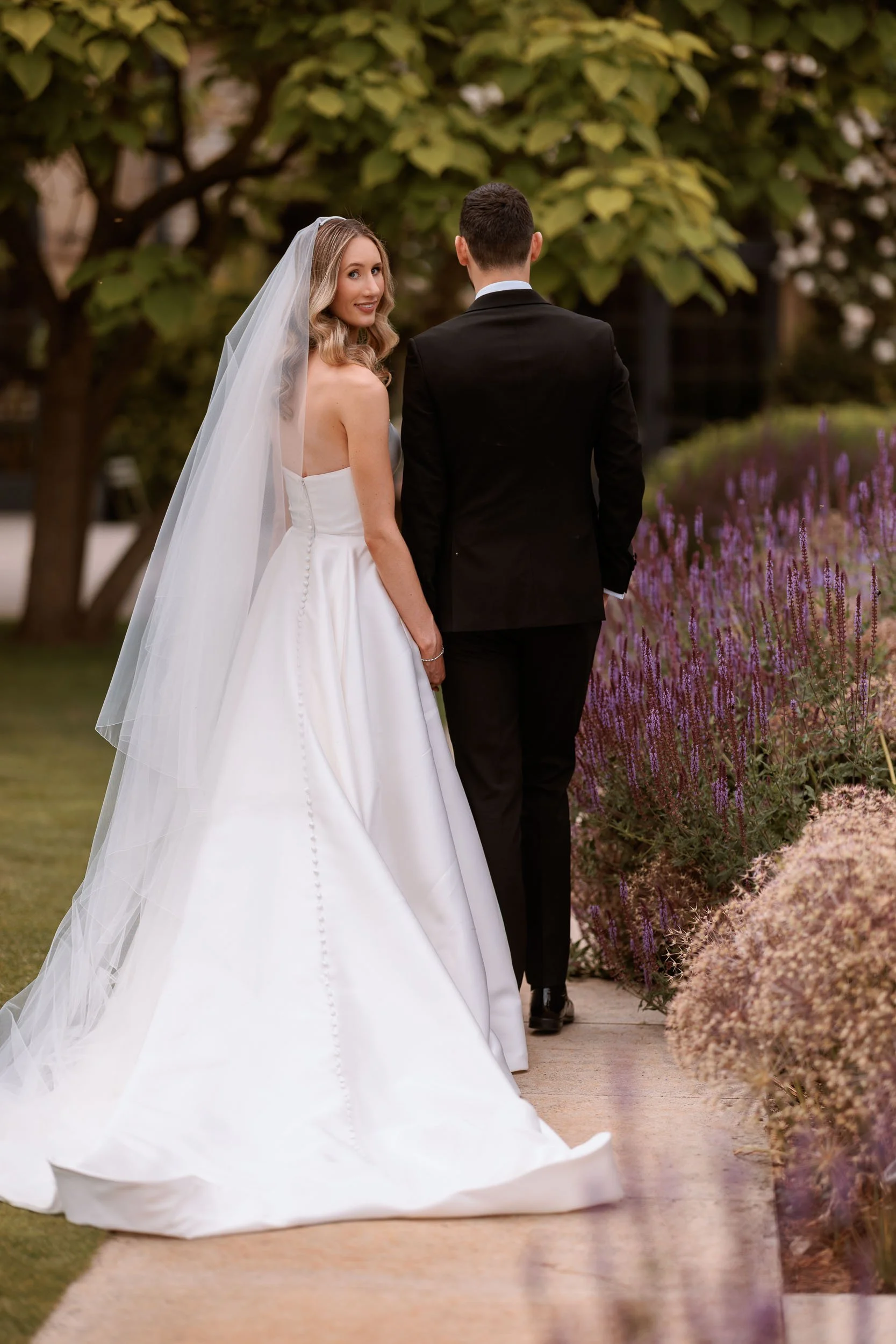 Newlyweds walking through the Walled Gardens at Middleton Lodge.
