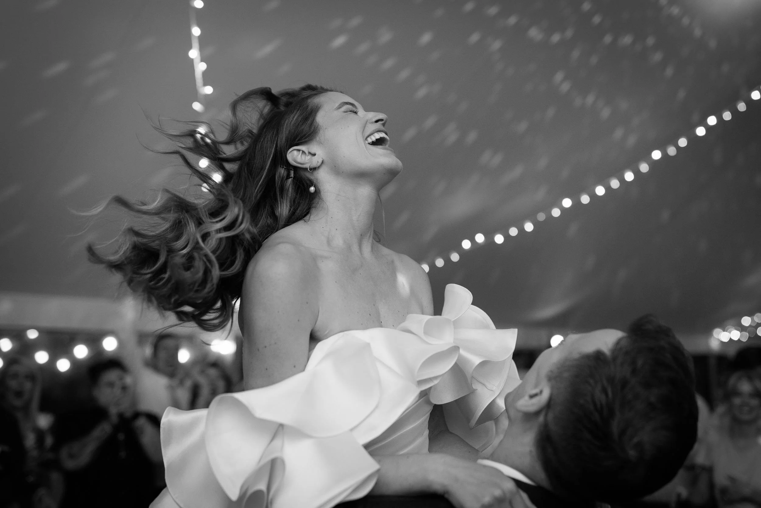 Black-and-white photograph capturing a joyful wedding celebration at Newburgh Priory, North Yorkshire.
