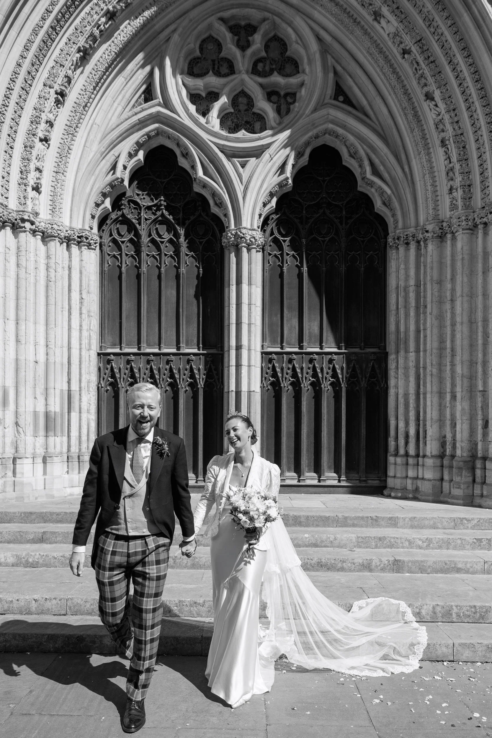 Newly married couple walking together outside York Minster after their wedding ceremony