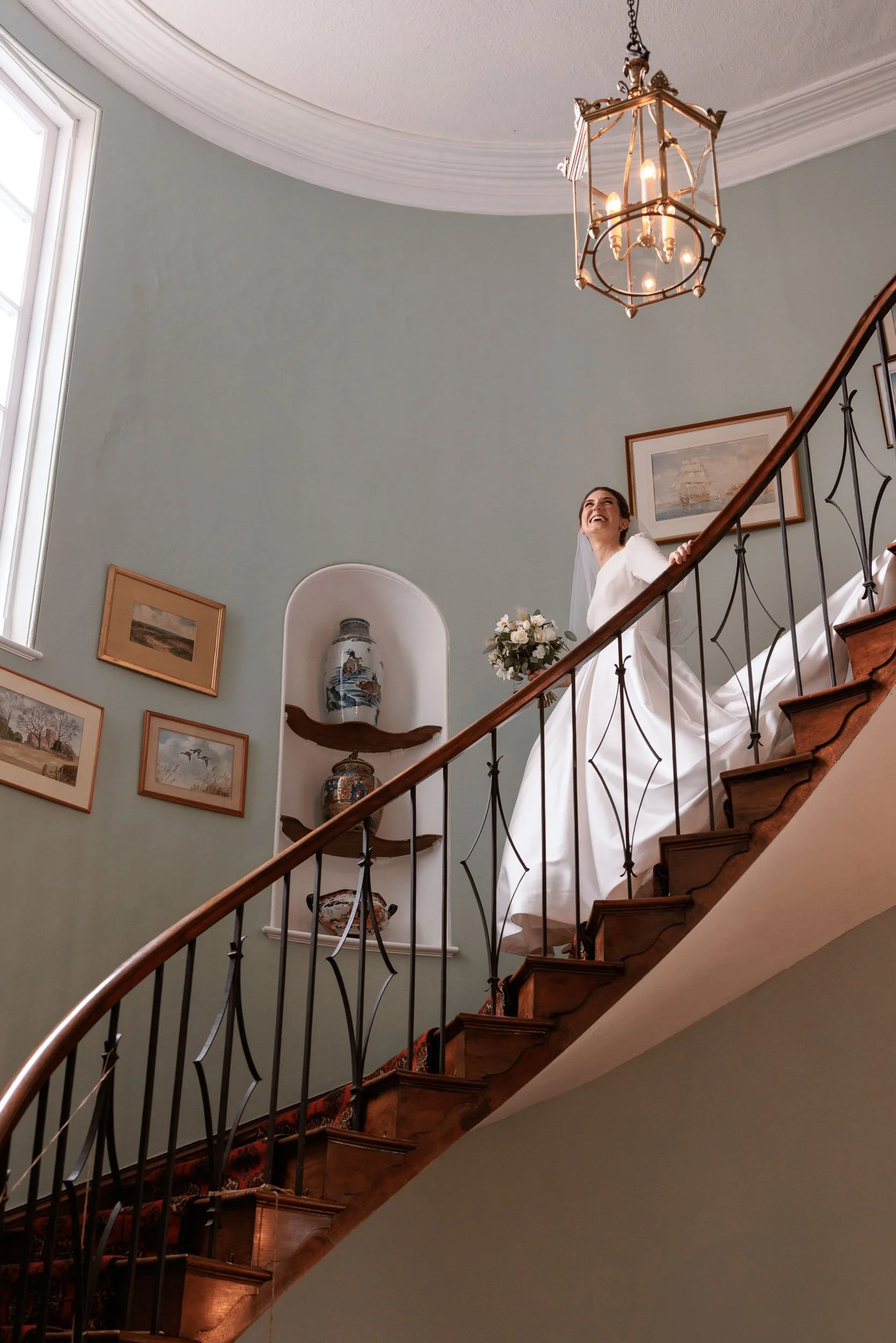 Reportage natural moment as the brides walks down the staircase on her luxury wedding day at Homme House.