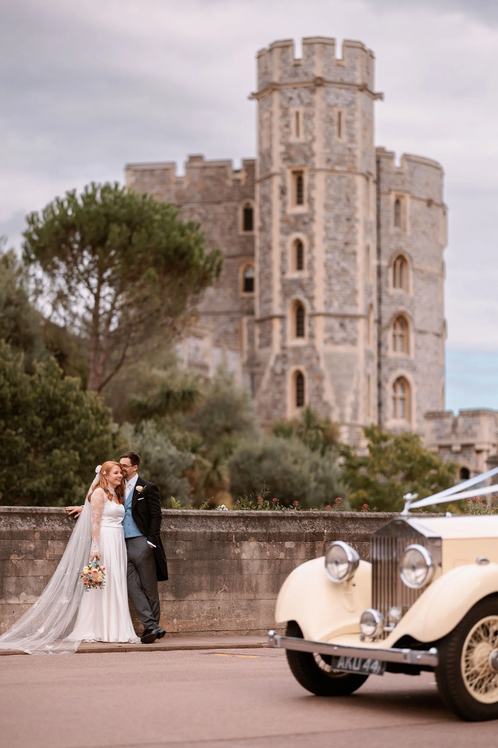 Clemmie and James beside their vintage wedding car at Windsor Castle following their St George’s Chapel ceremony.