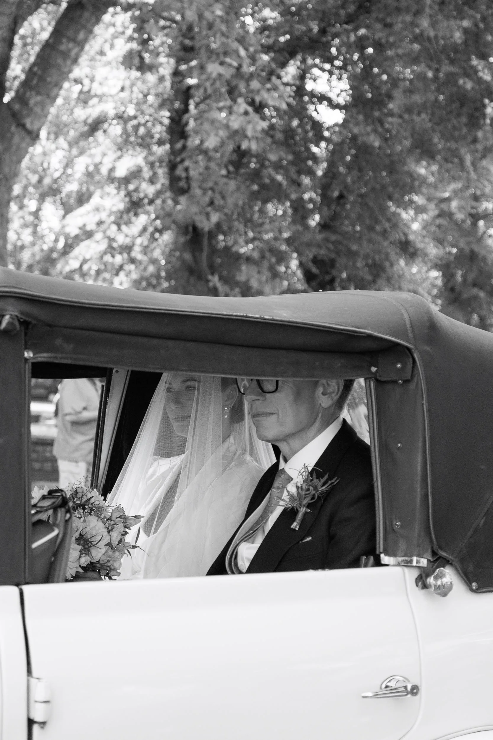 Bride and groom travelling together in a vintage wedding car